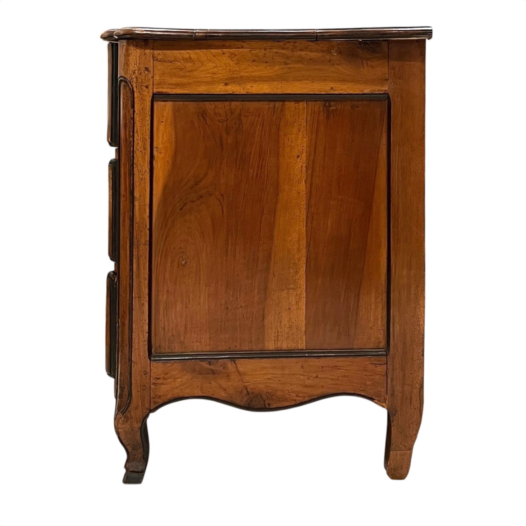 A refined French walnut chest featuring contrasting black accents and elegant brass hardware, combining warm wood tones with bold detailing—offering a sophisticated blend of classic craftsmanship and striking visual appeal.
