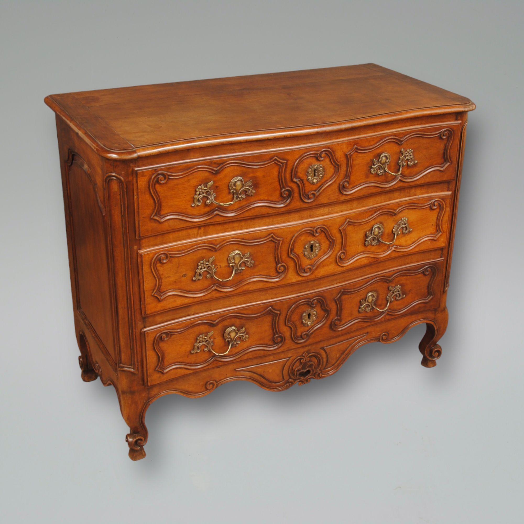 A good example of a carved french walnut commode with a slight bow fronted design, paneled to the ends and with french scroll feet. original handles and good colour and condition throughout.
Circa 1770