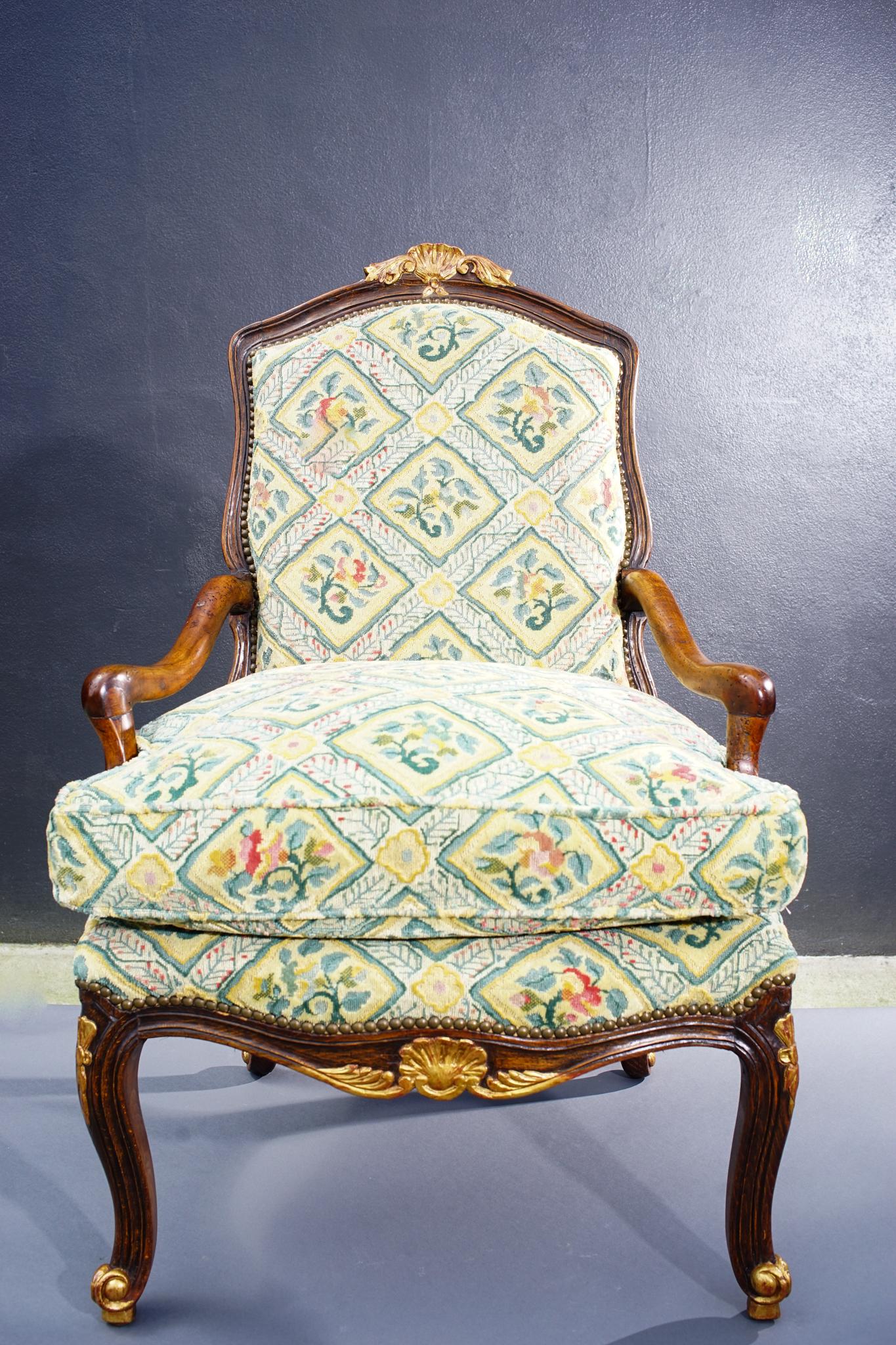 Single 18th century French carved walnut Regence armchair with gilt details. Newly upholstered in Old World Weavers material.