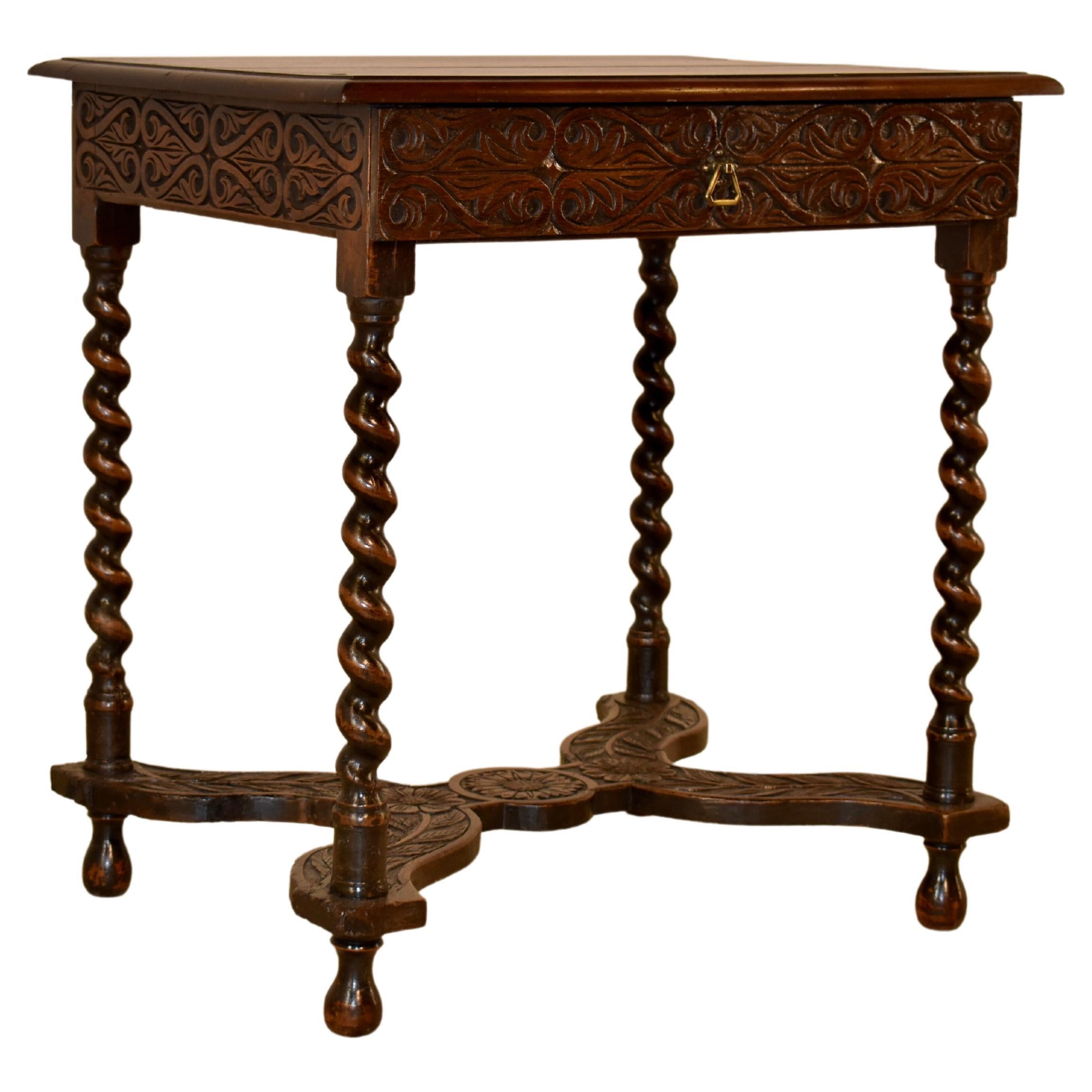 Louis XV period 18th century walnut side table from France. The top is made from two planks, with a beveled edge and pegged construction. The top follows down to hand carved decorated aprons, and a single drawer in the front. The table is supported
