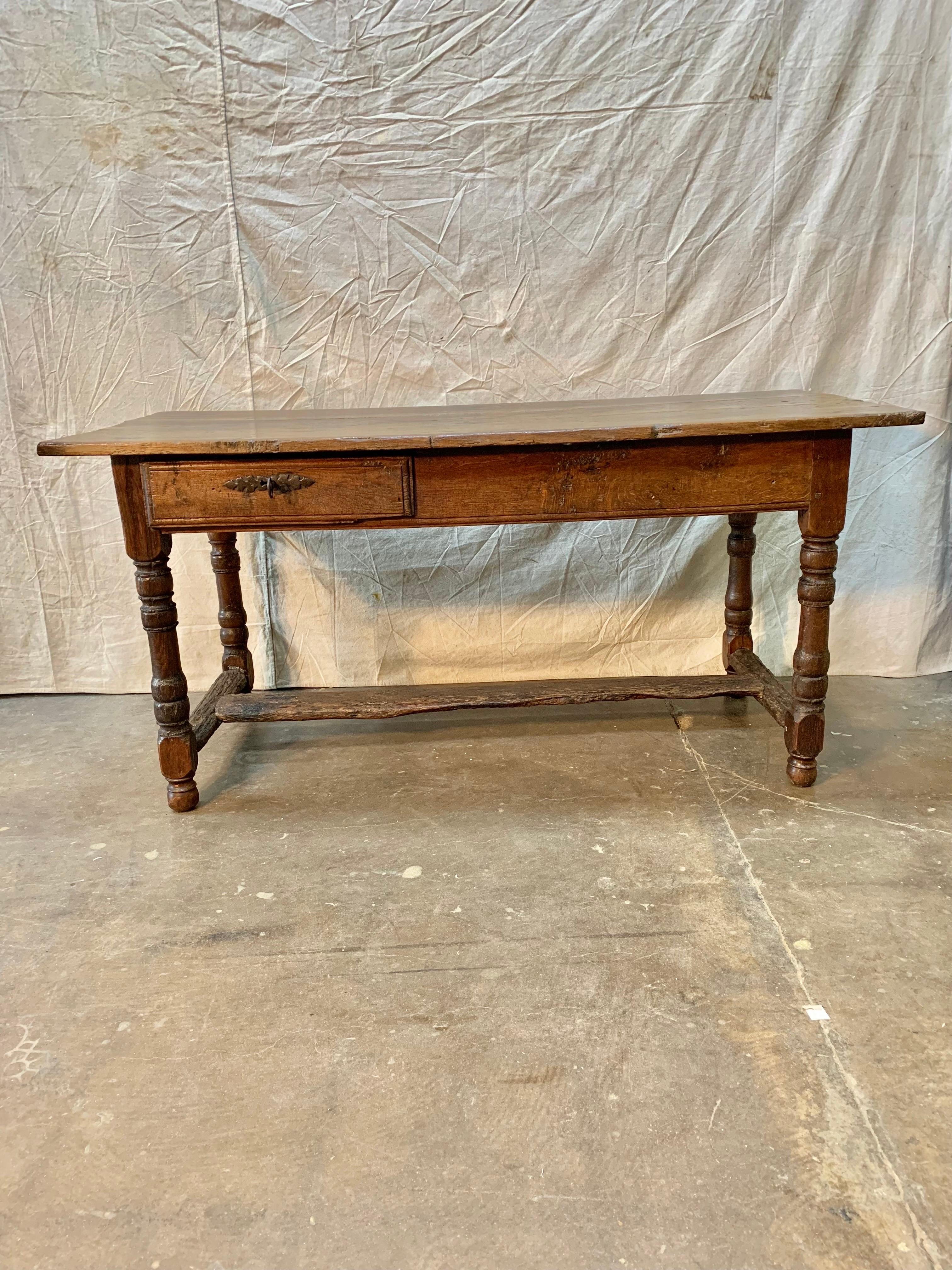 Found in the South of France, this French Bakers Table was handcrafted by artisans from old growth walnut. The piece features a three plank top resting above two drawers, one front drawer with its orginal working lock and key and an enlongated