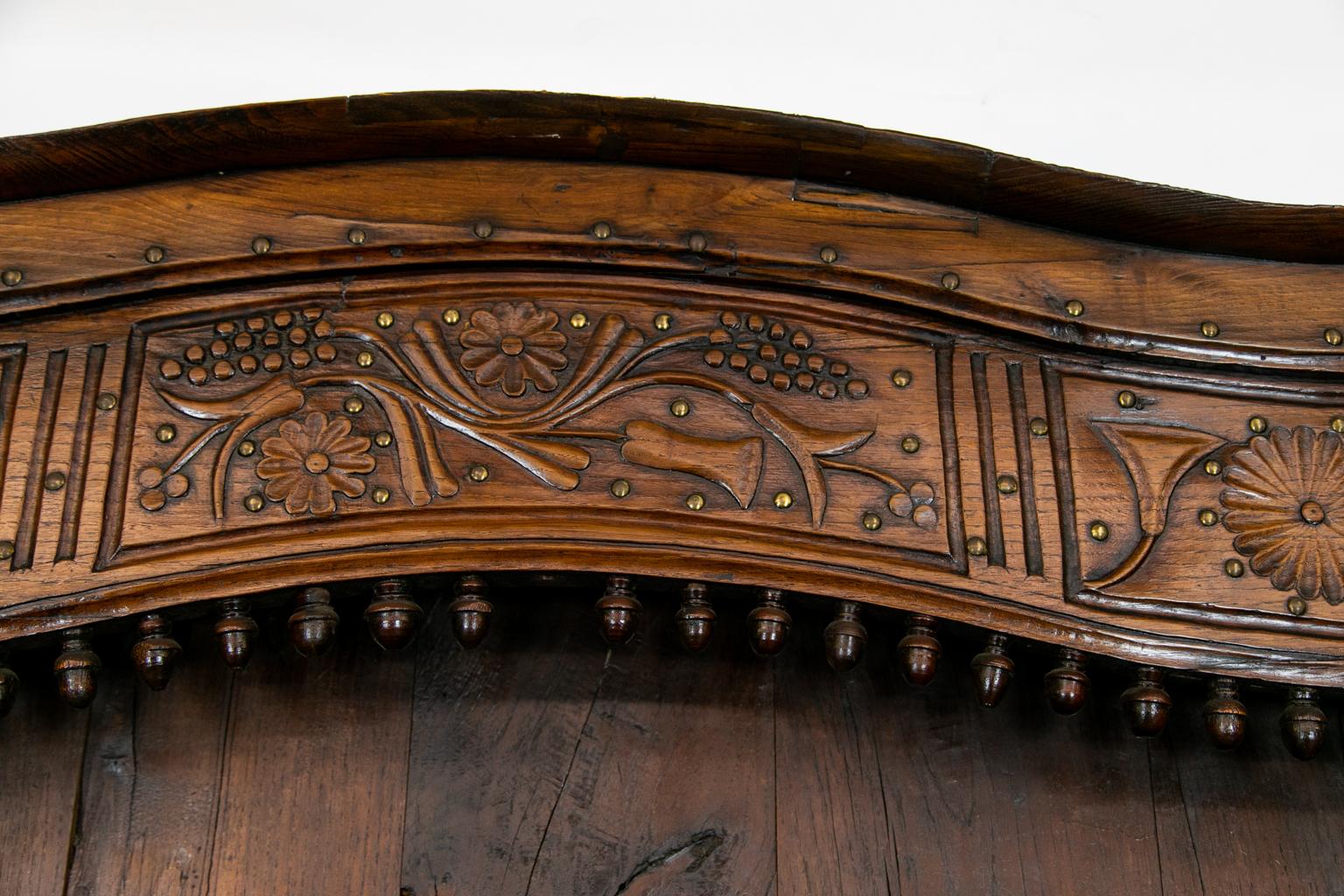 18th century French Walnut vasselier, with floral carvings and brass stud work ornamentation. Large original engraved escutcheons grace the front. The top has a serpentine shaped crest. Molded spindle galleries accent the three shelves. Elaborate