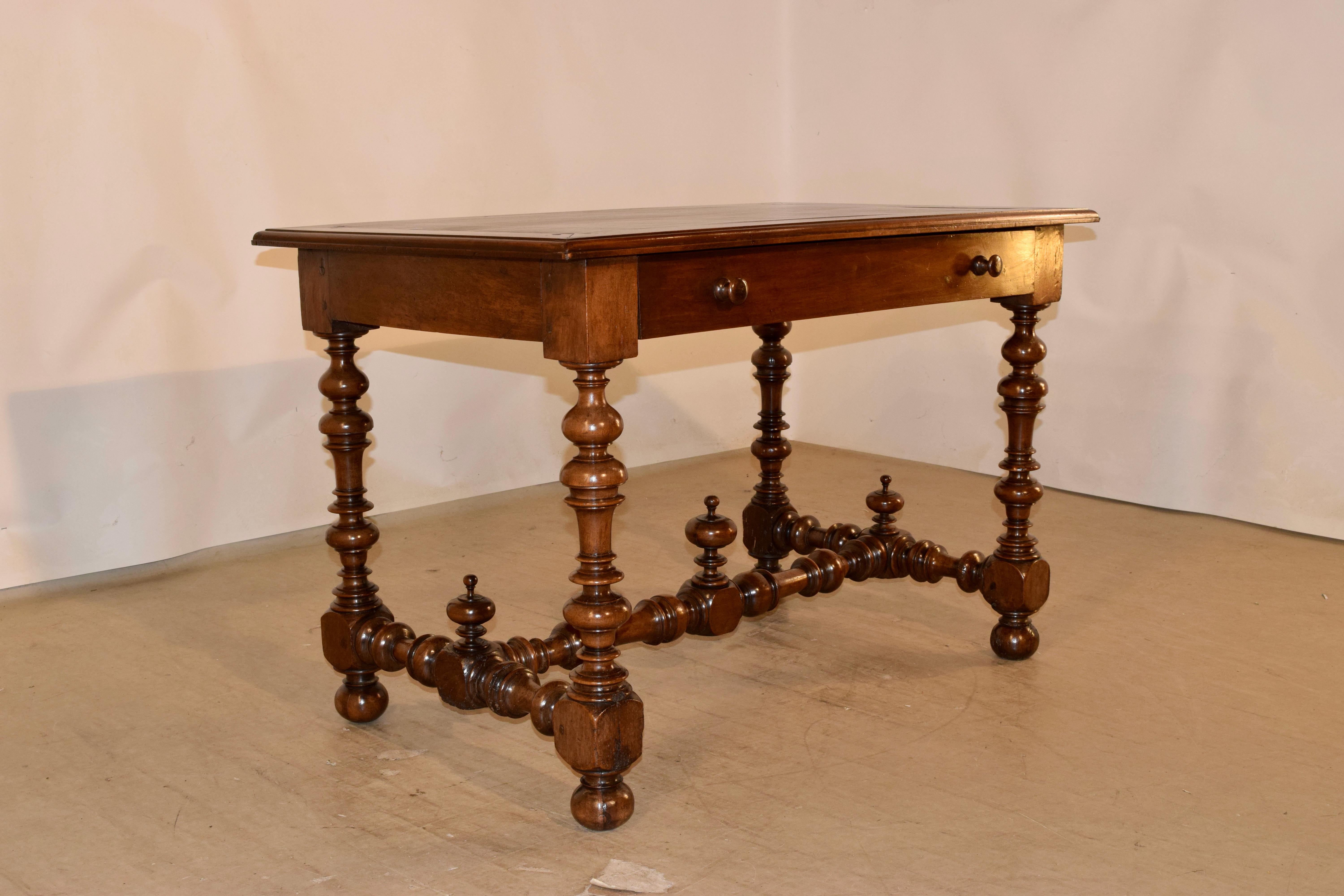 18th century walnut writing table with a banded and beveled edge around the top, following down to a simple apron containing a single drawer in the front and supported on hand turned legs joined by matching cross stretchers and finished with a
