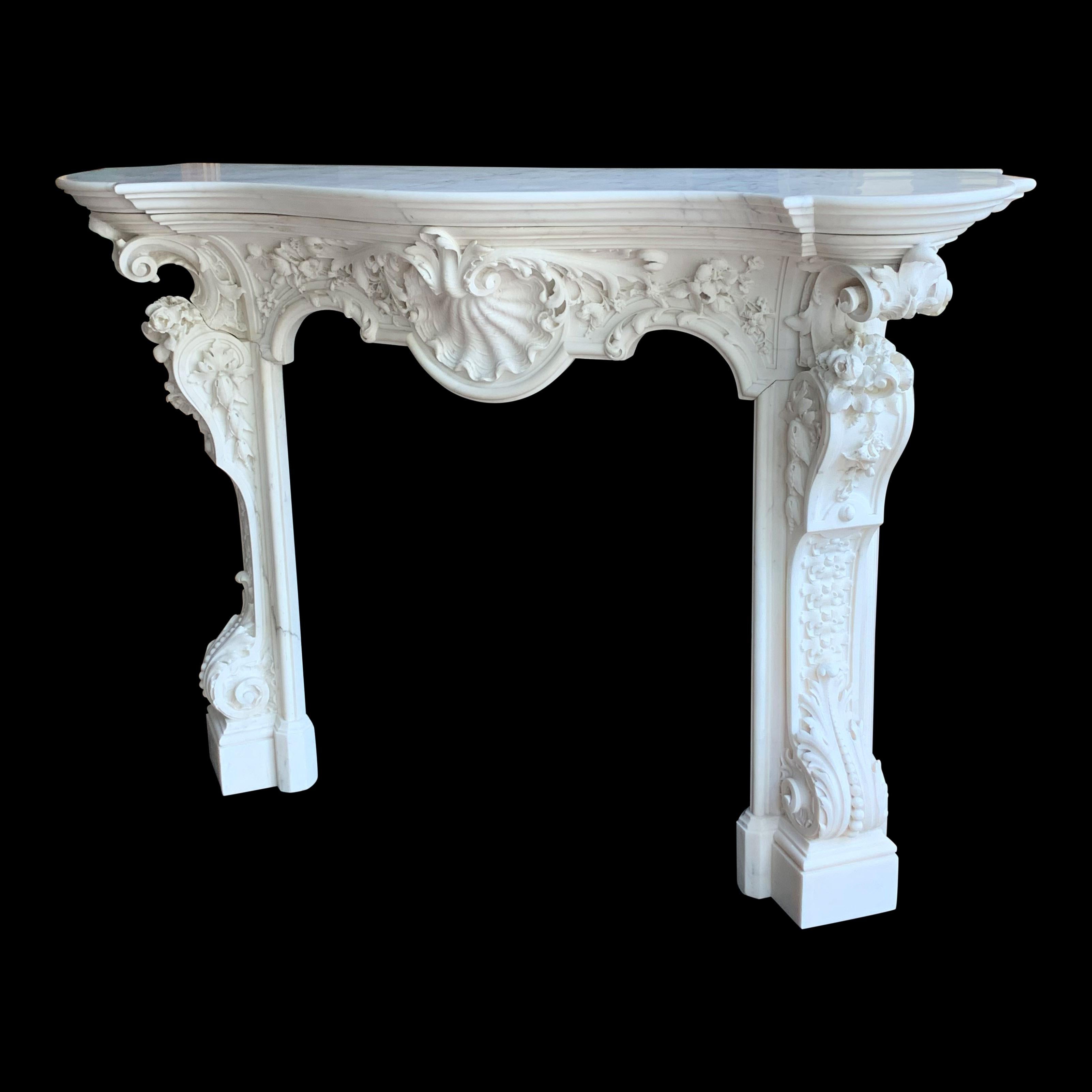 A pure statuary 18th century French Chimneypiece.
The Frieze consisting of a dramatic carved shell cartouche with bold acanthus foliage sweeping to either side with floral enrichment. The Jambs have elongated decorated consoles with an acanthus