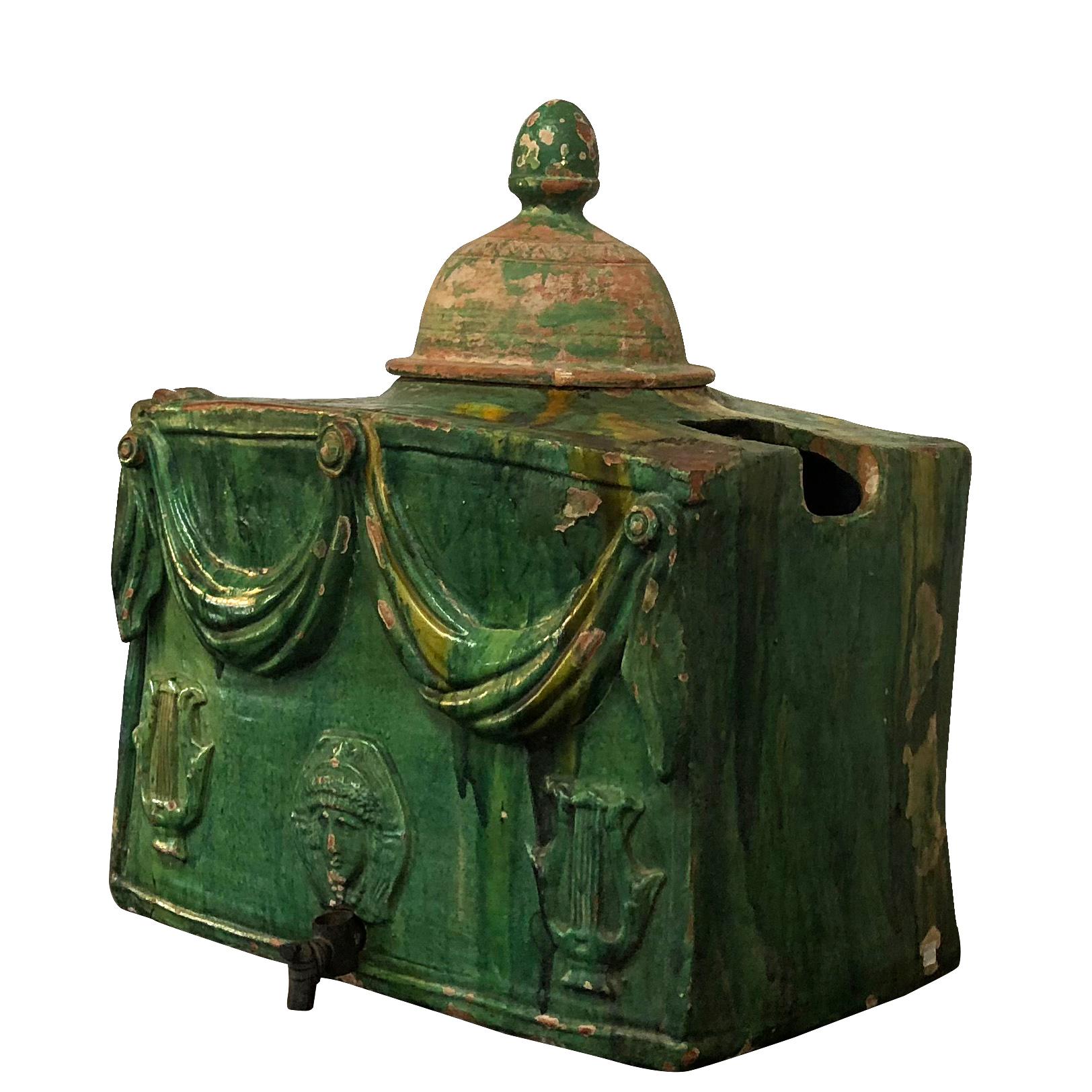 An antique French wine or water cooler glazed the traditional Provençal colors green, yellow and ochre made of glazed terra cotta, in good condition. The rectangular cooler is decorated with swags in the front and is topped with the original lid.