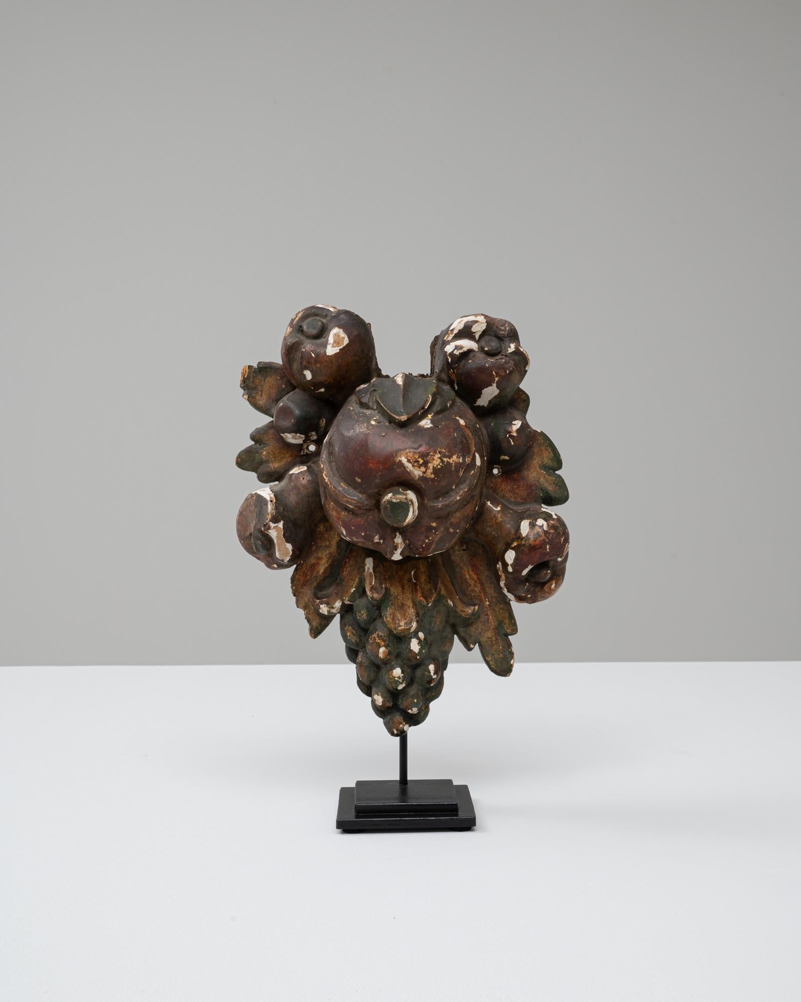 Questa decorazione barocca in legno francese del XVIII secolo è un frammento riccamente intagliato trasformato in un sorprendente oggetto scultoreo. Caratterizzato da un abbondante grappolo di frutta - probabilmente melograni, bacche e uva - cattura