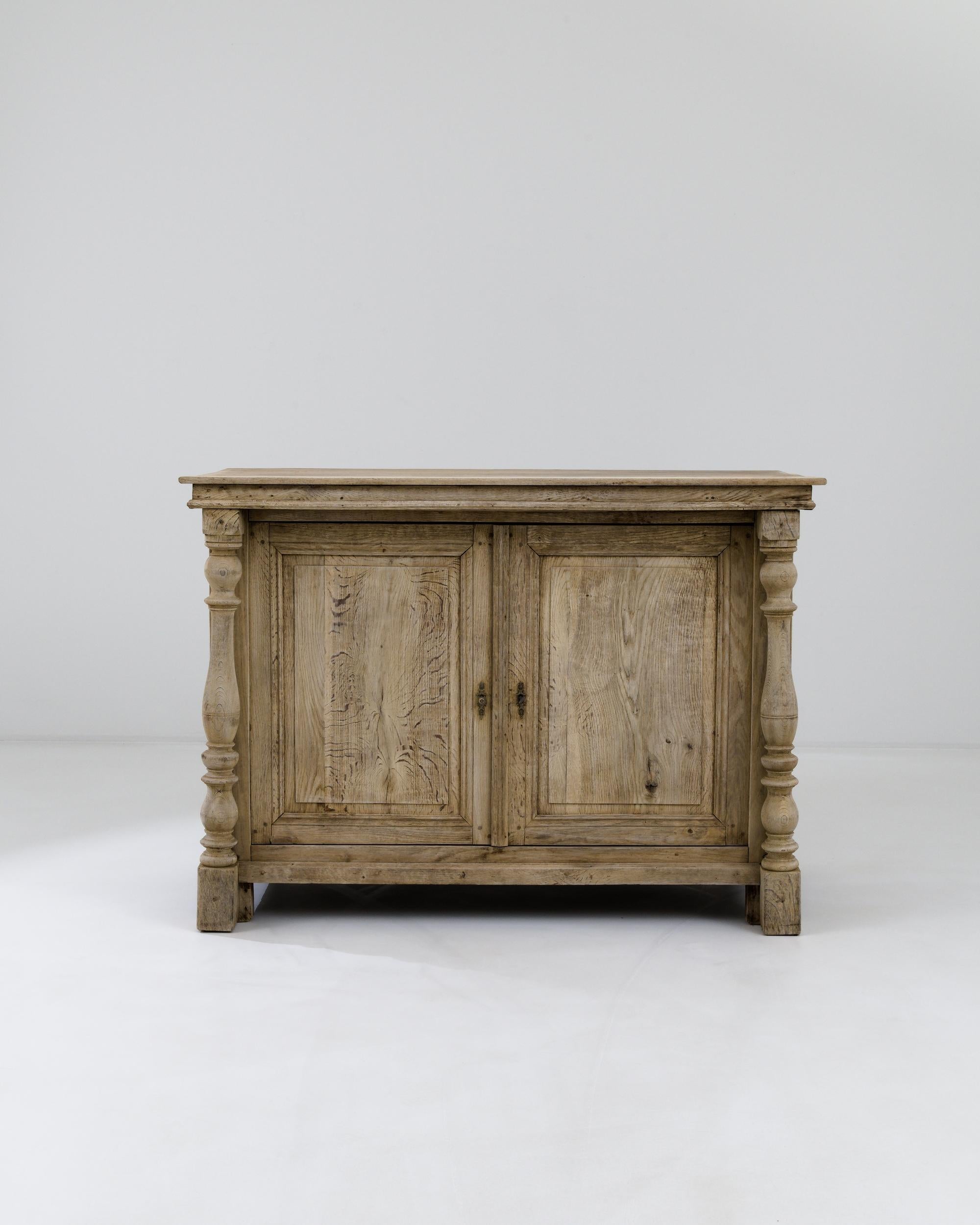 A wooden buffet created in 18th century France. This large and impressive buffet exudes a sense of traditional dignity, emphasized by its masterful construction and delightful details. Sumptuously lathed legs and lovingly crafted brass hardware