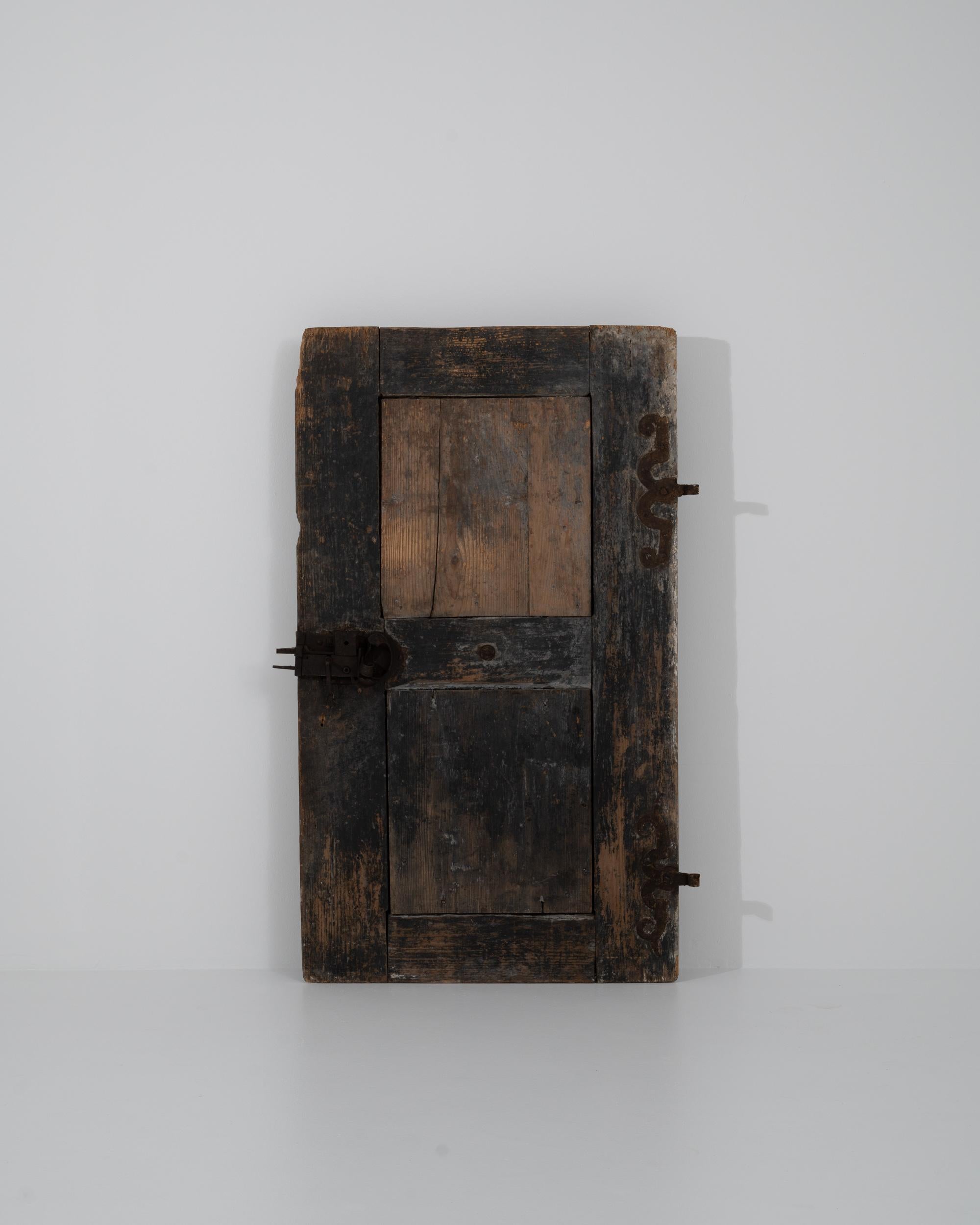 This antique wooden door offers an intriguing historical accent. Made in France in the 1700s, the door is notably small in stature —doors and windows at this time were often made as small as possible in order to minimize heat loss in the chilly