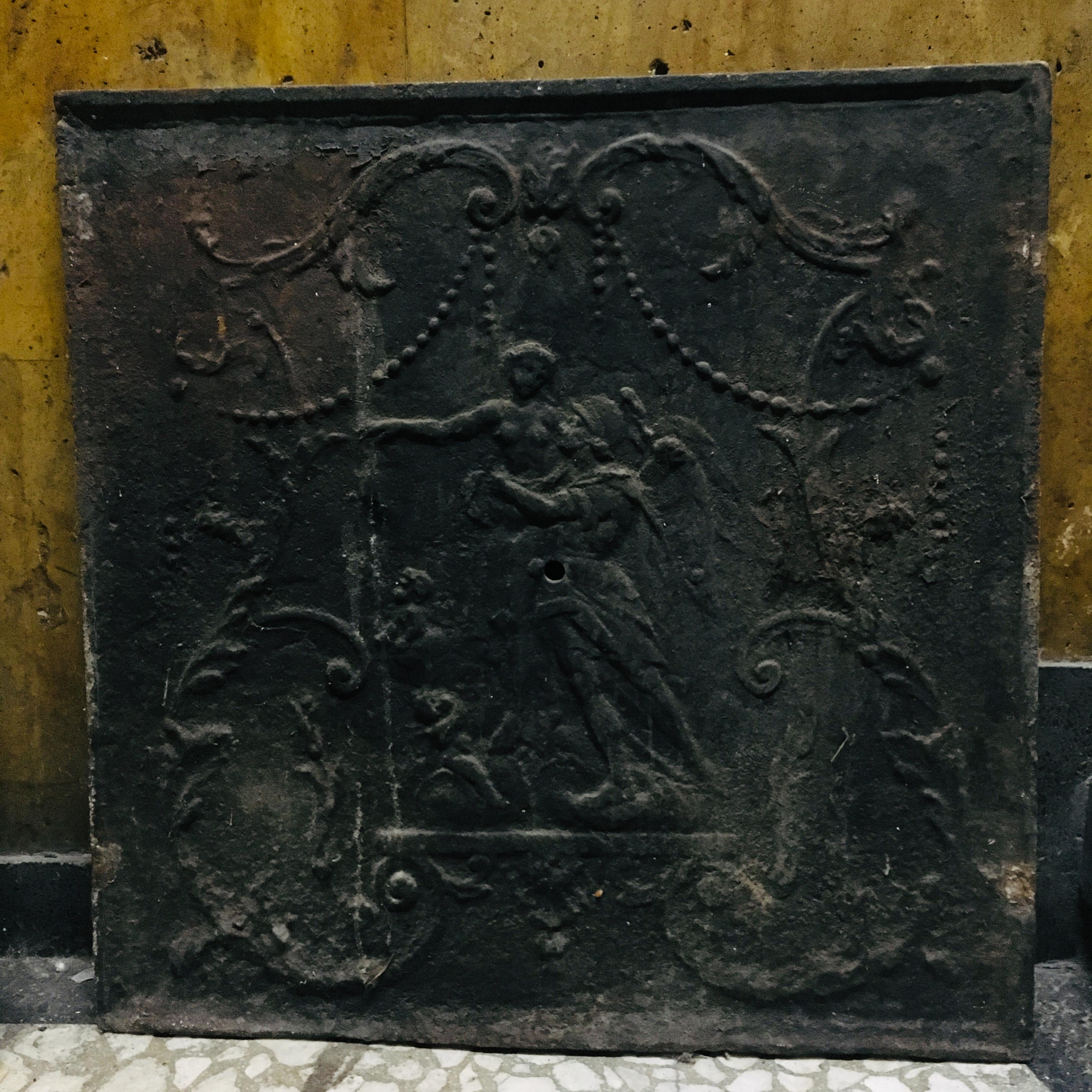This antique iron fire back plaque was crafted in France, circa 1760.
This forged piece could be used inside a fireplace hearth to re-direct heat, or as a back splash behind the stove in a kitchen. The rustic plaque has wonderful details