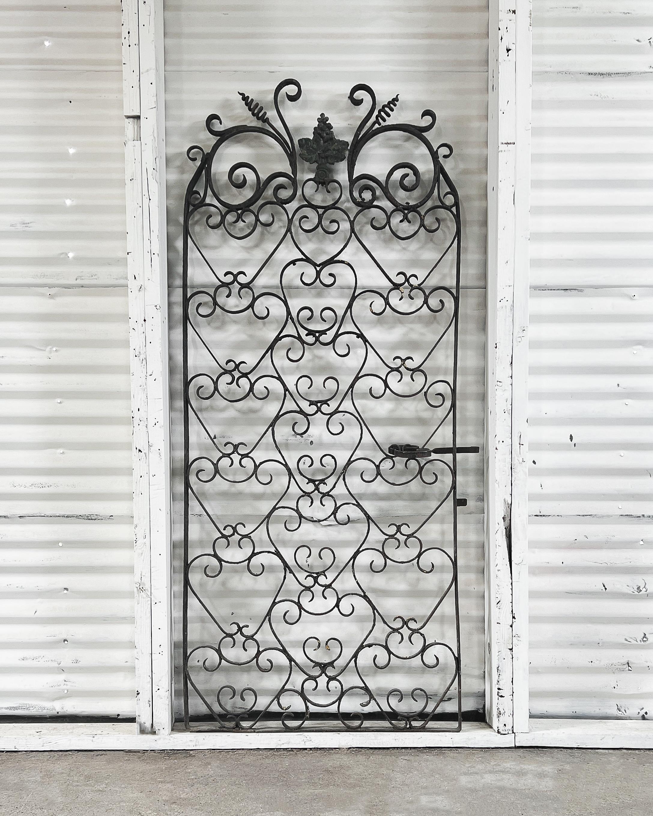 Found in France and crafted in the late 18th century, this beautiful wrought iron wine cellar gate has a wonderful time-worn patina. A wonderful decorative piece for the home, the gate features decorative scrollwork and is topped with a leafy