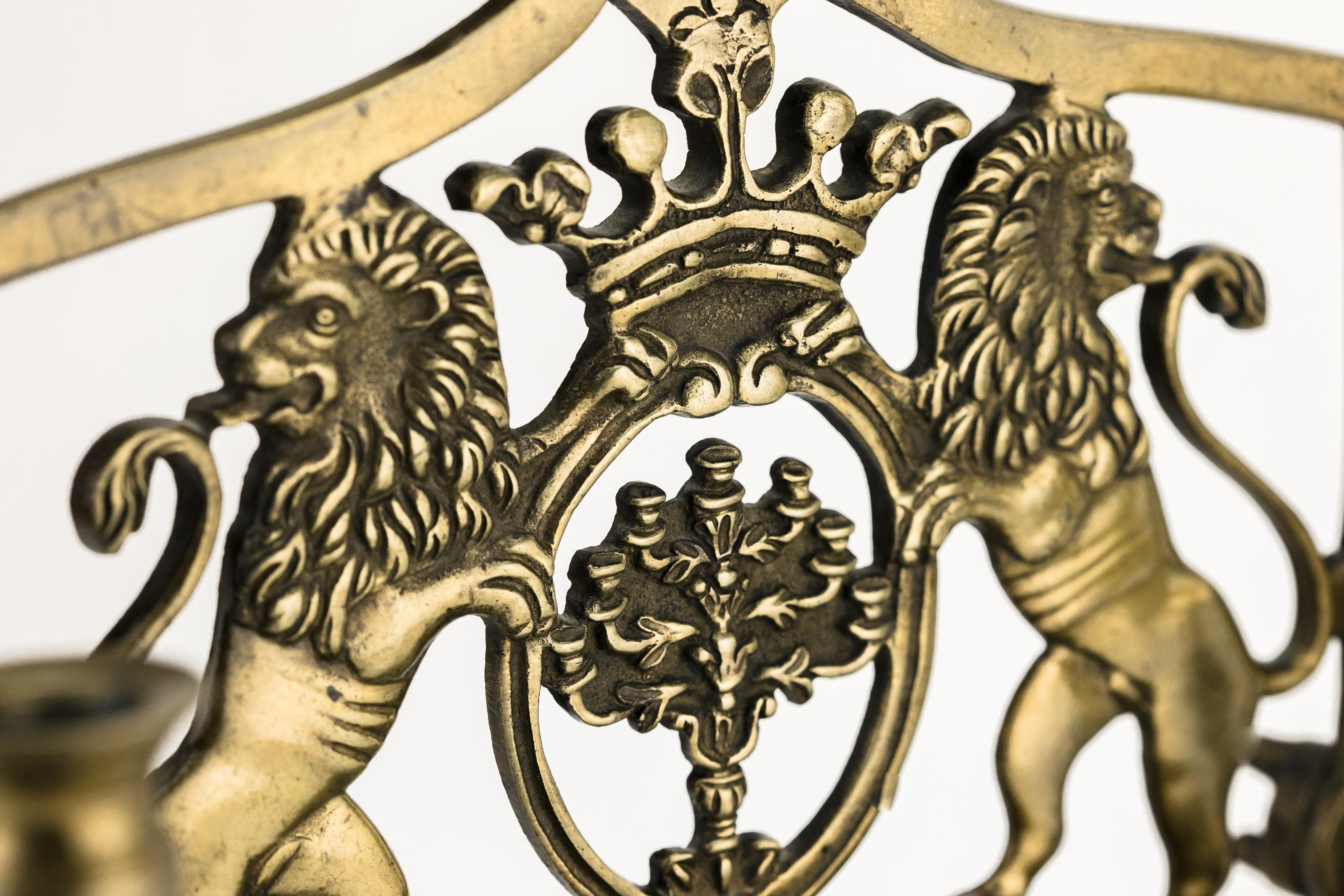The backplate is cast with two rampant Lions of Judah flanking a topped crown cartouche with the Temple Menorah inside, the side panels fitted with two servant lights, fronted by a row of eight oil fonts with the boxed drip pan.
Scholars theorize