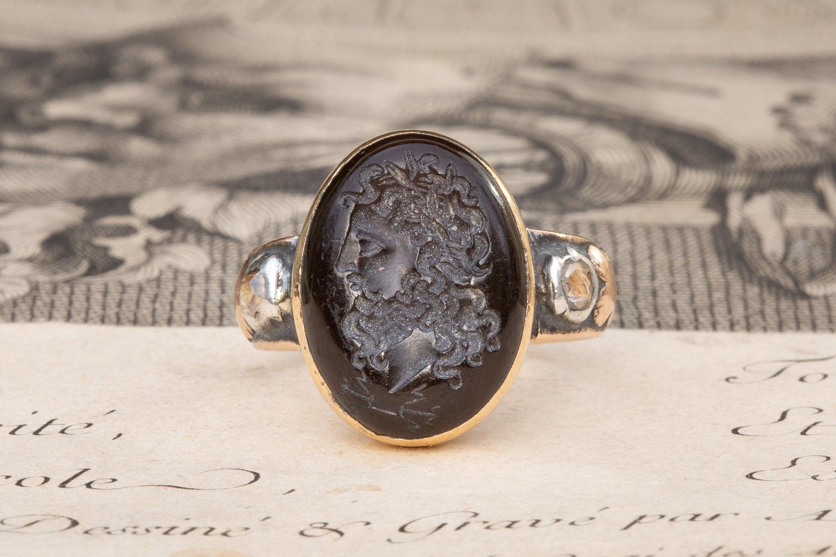 Rare Antique Late 18th Century Garnet Intaglio Signet Ring with Rose Cut Diamonds

This fantastic signet ring dates to around 1780 and was made in Paris. A closed-back and bezel set 3.7ct garnet cabochon gemstone is intricately engraved to depict
