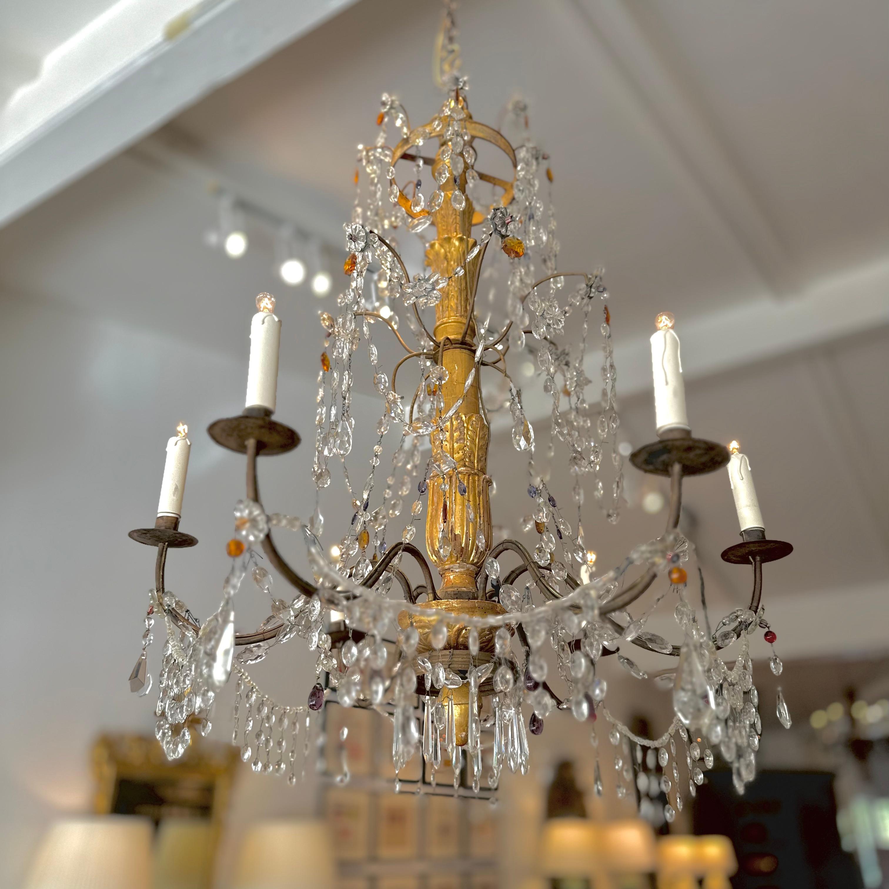 Genovese Louis XVI chandelier in carved and gilded wood, circa 1780, similar to the chandeliers in the Palazzo Ducale in Genoa. It consists of a central shaft in turned, carved and gilded wood with six curved iron arms, decorated with period