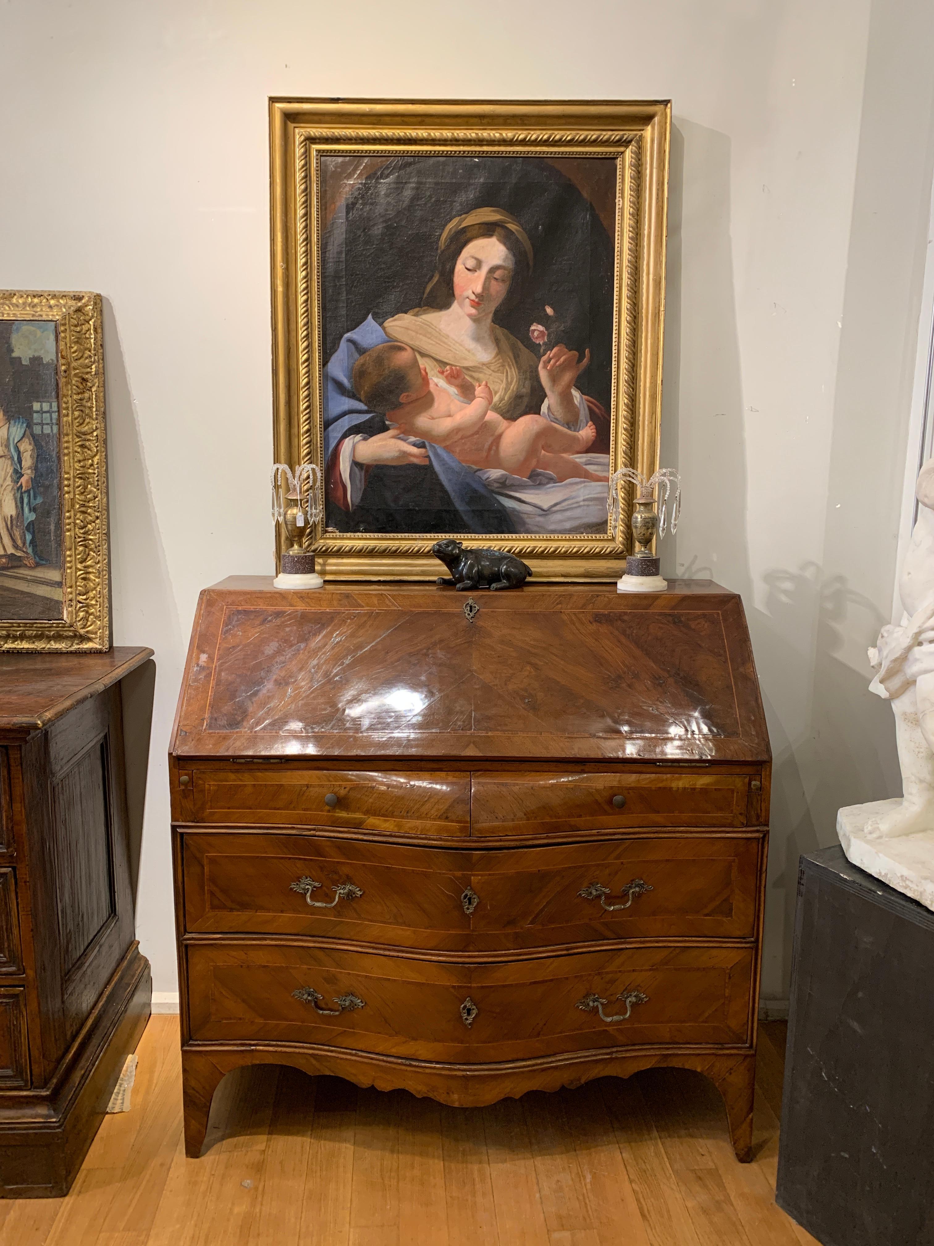 Elegant wall desk with folding top. The piece of furniture was worked partly in solid walnut and partly with walnut veneer. On the front the typology is wavy/convex and has four original drawers. Furthermore, on the sides of the first drawer from