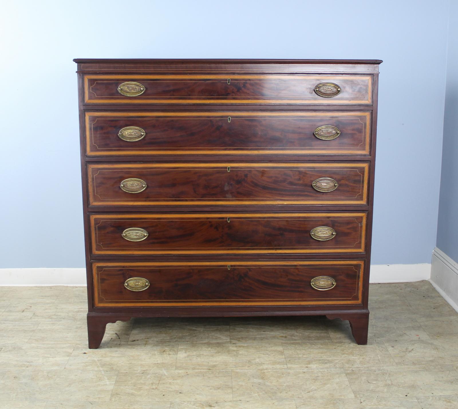 A handsome, imposing and quite early large gentlemen's dresser. Five wide drawers open and close nicely. Beautifully grained veneered mahogany drawer fronts with inlaid satinwood edging and stringing. Brass handles appear to be replaced. Good
