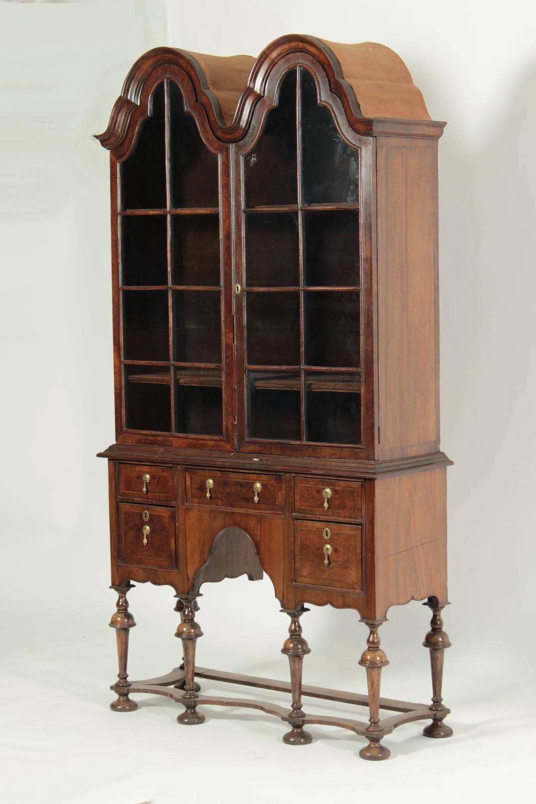 18th century double tombstone top walnut display cabinet on stand

--wonderful patina wood figuring
--original glass and finish
--trumpet legged base
--wonderful moderate height

Provenance: Ex Christies.