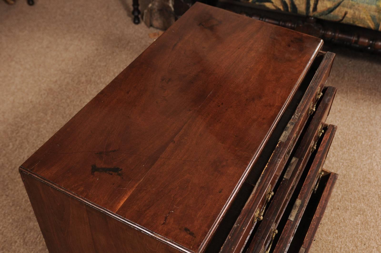 The mid-18th century George II mahogany bachelor's chest having a caddy top above four graduating drawers with brass hardware and terminating in bracket, feet. 

 