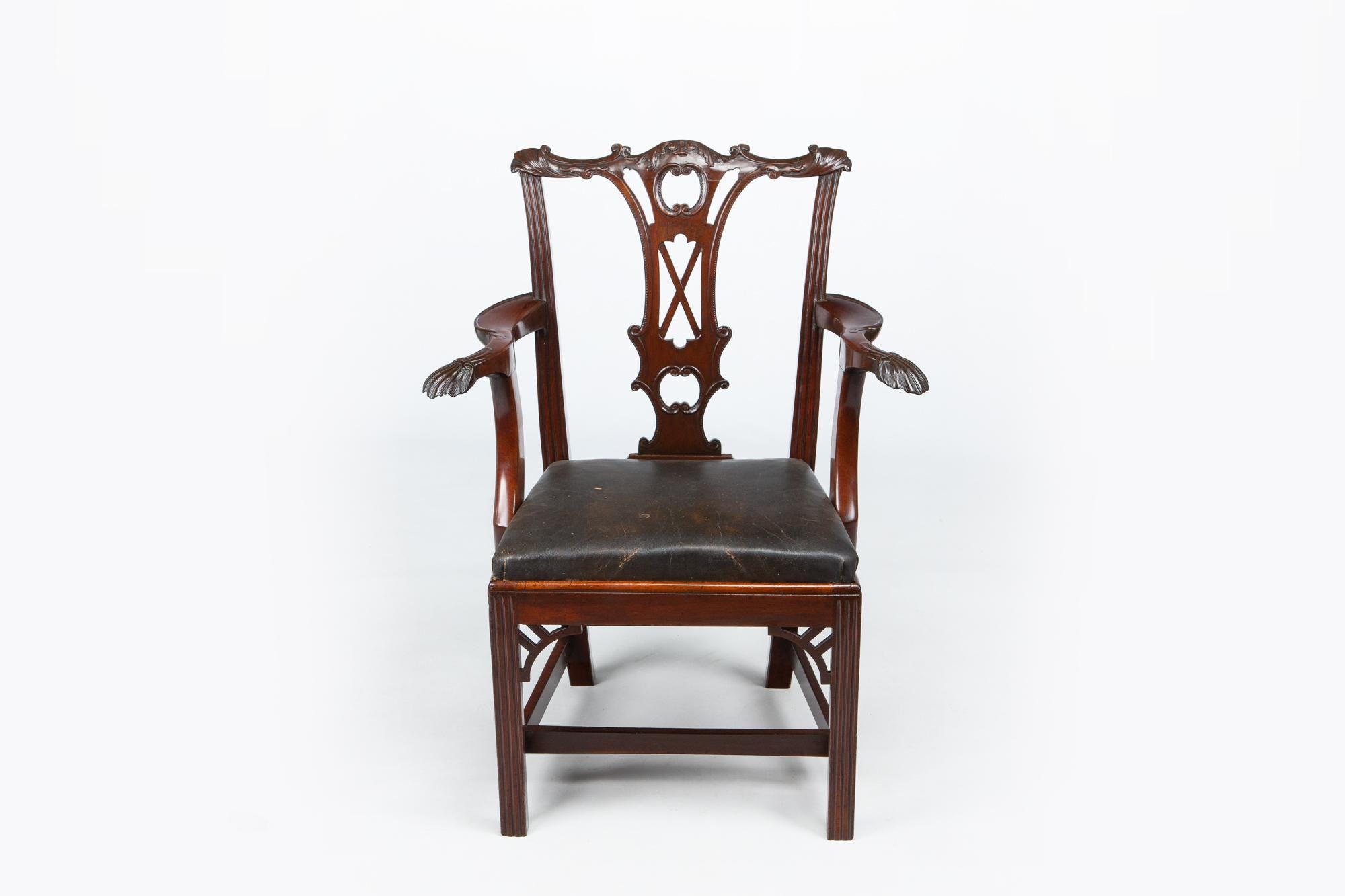 18th century George II Irish carver in the manner of Chippendale, the bow shaped back rail centred with carved bell husk motif flanked with scrolling acanthus leaf and C-scrolls and moulded corners raised over pierced interlocking back splat with