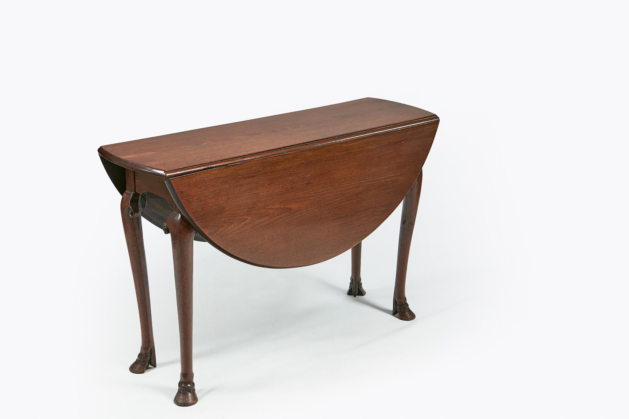 18th century George II Irish mahogany drop-leaf table, the moulded top of oval form incorporating twin hinged leaves, raised above moulded frieze supported on cabriole leg with carved scroll terminals terminating in hoof foot, circa 1750.