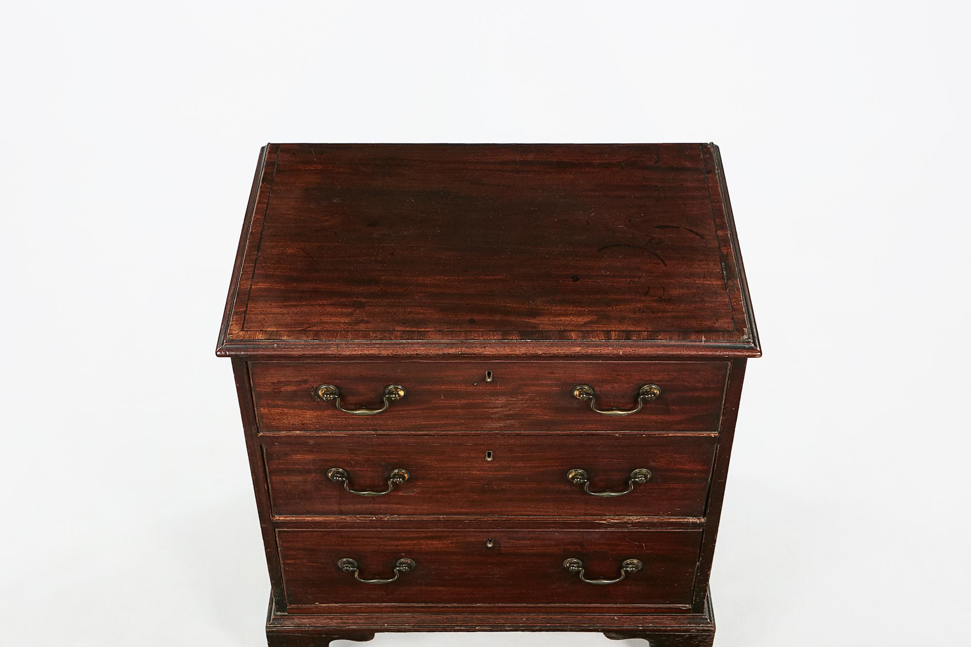 18th century George II crossbanded line inlaid mahogany chest of drawers, the moulded top raised over three graduated long cockbeaded drawers with brass pulls and escutcheons terminating on ogee bracket feet.