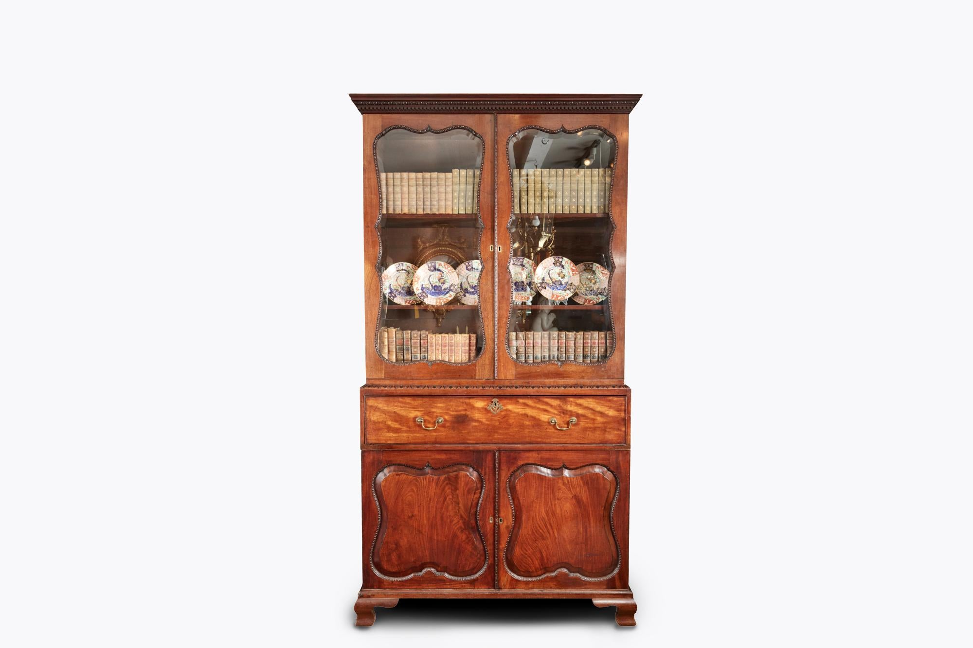 18th century George II mahogany secretaire bookcase attributed to Giles Grendy (1693-1780). Featuring a cornice with egg and dart and dentil mouldings, above a pair of doors with cartouche-shaped bevelled glass panels, outlined with conforming egg