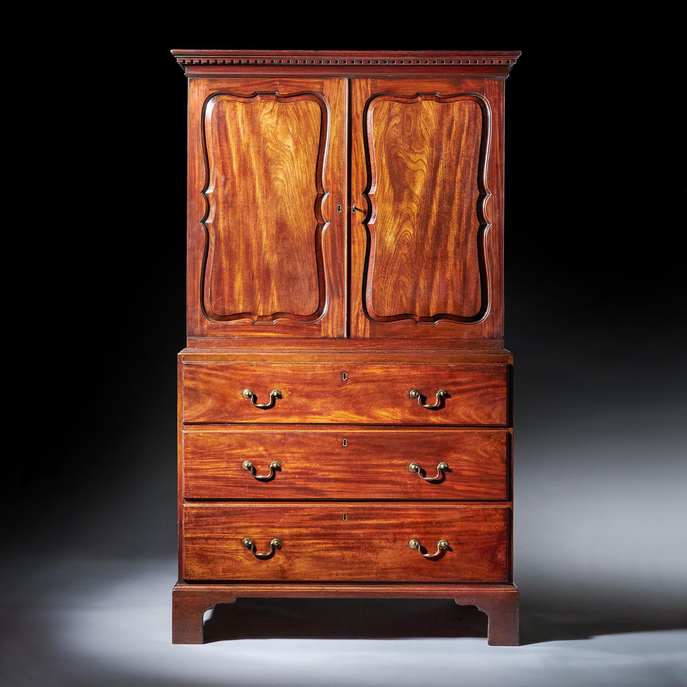 A fine and rare 18th century two-part George II mahogany secretaire linen press, circa 1750-1760. England. Attributed to Giles Grendey. 

The detailed dentil moulded cornice sits above a pair of raised and fielded figured mahogany shaped doors