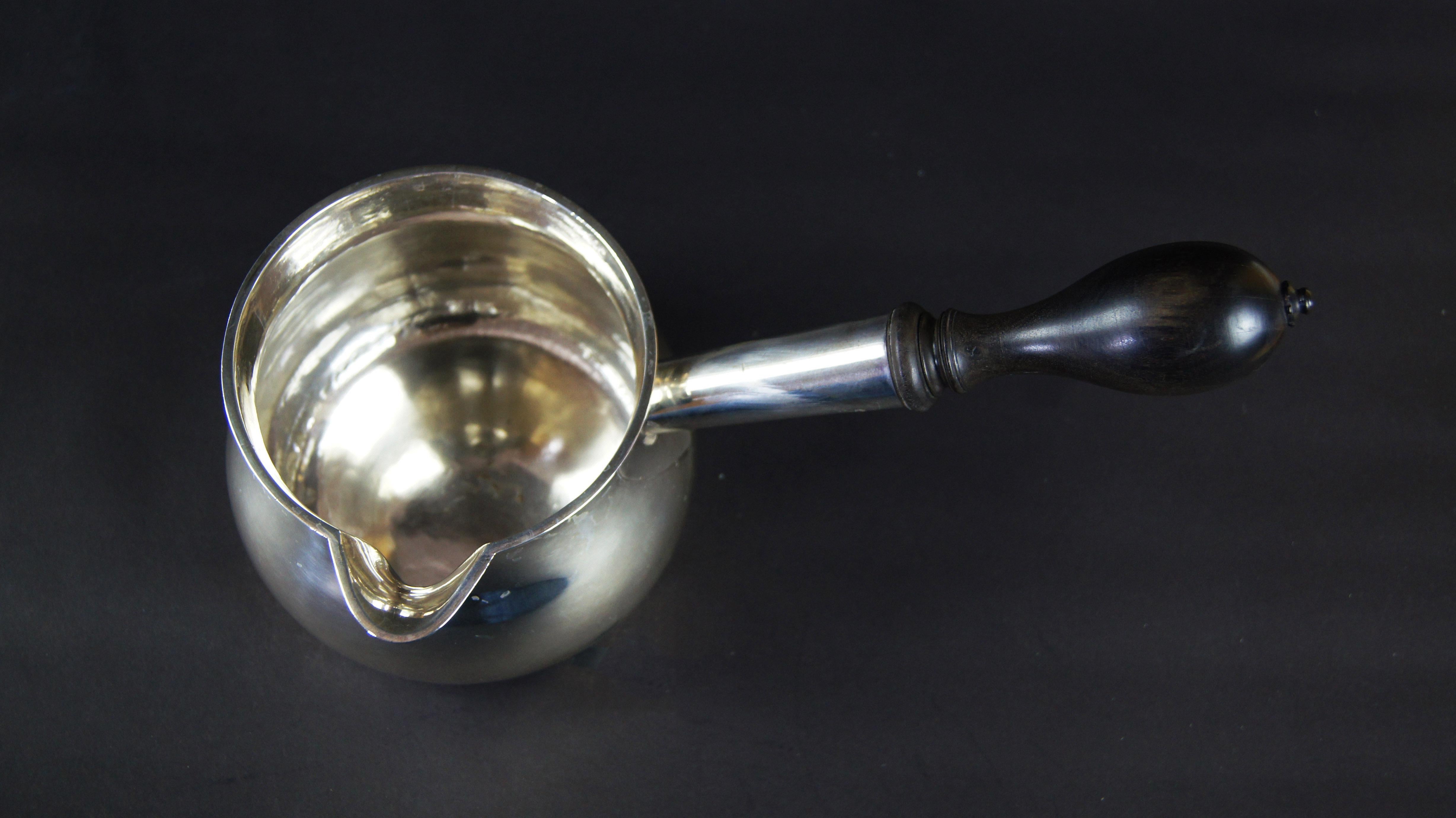 A large George II silver brandy saucepan, hallmarked Frederick Kandler, London, 1758. With a bulbous body and turned and ebonized wood handle, undecorated.