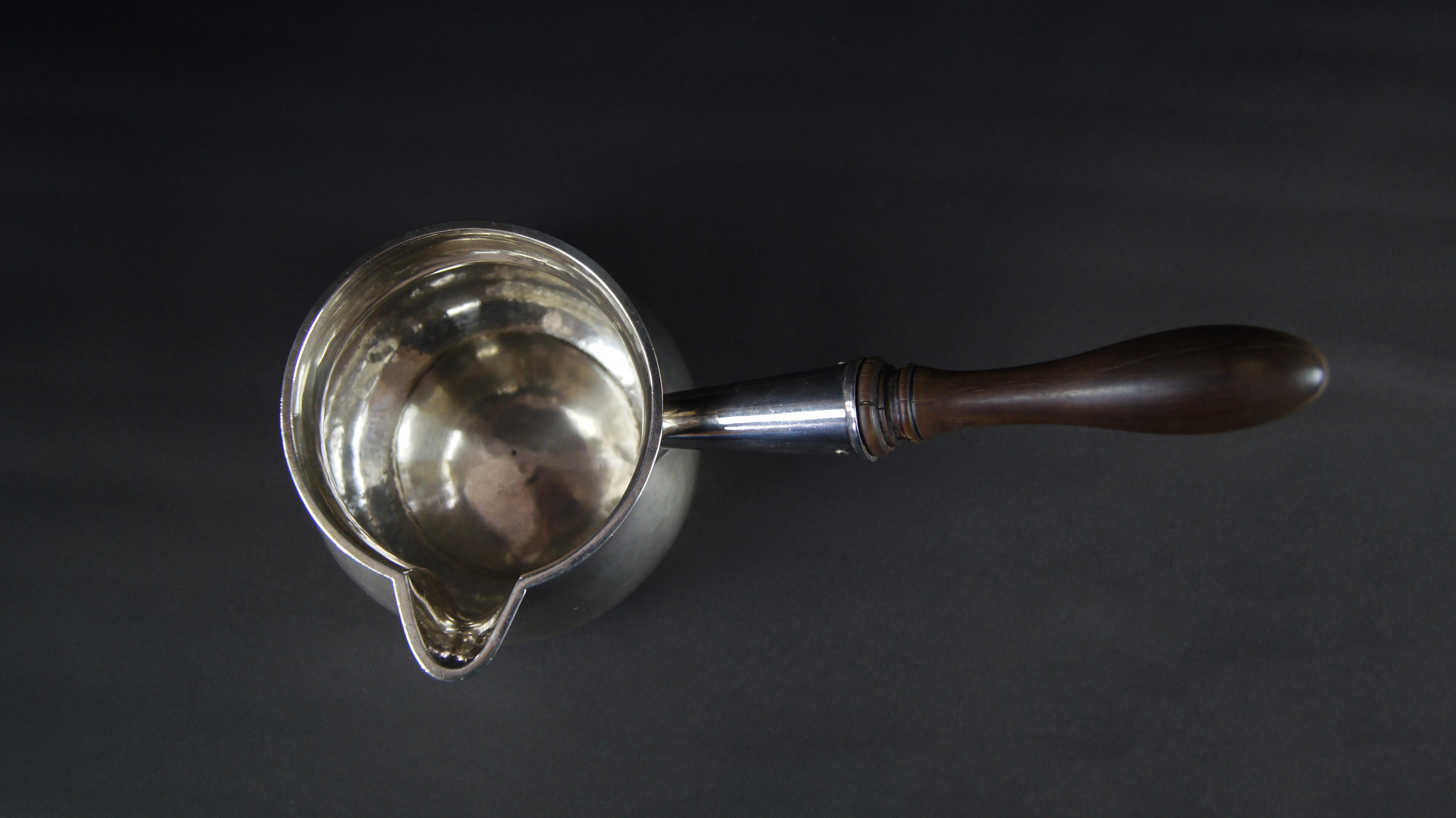 A large George II silver brandy saucepan, hallmark of John Swift, London, 1758. Of bulbous form with a turned baluster shaped mahogany handle, engraved with a viscount's coronet with a stag passant, weight 636g.