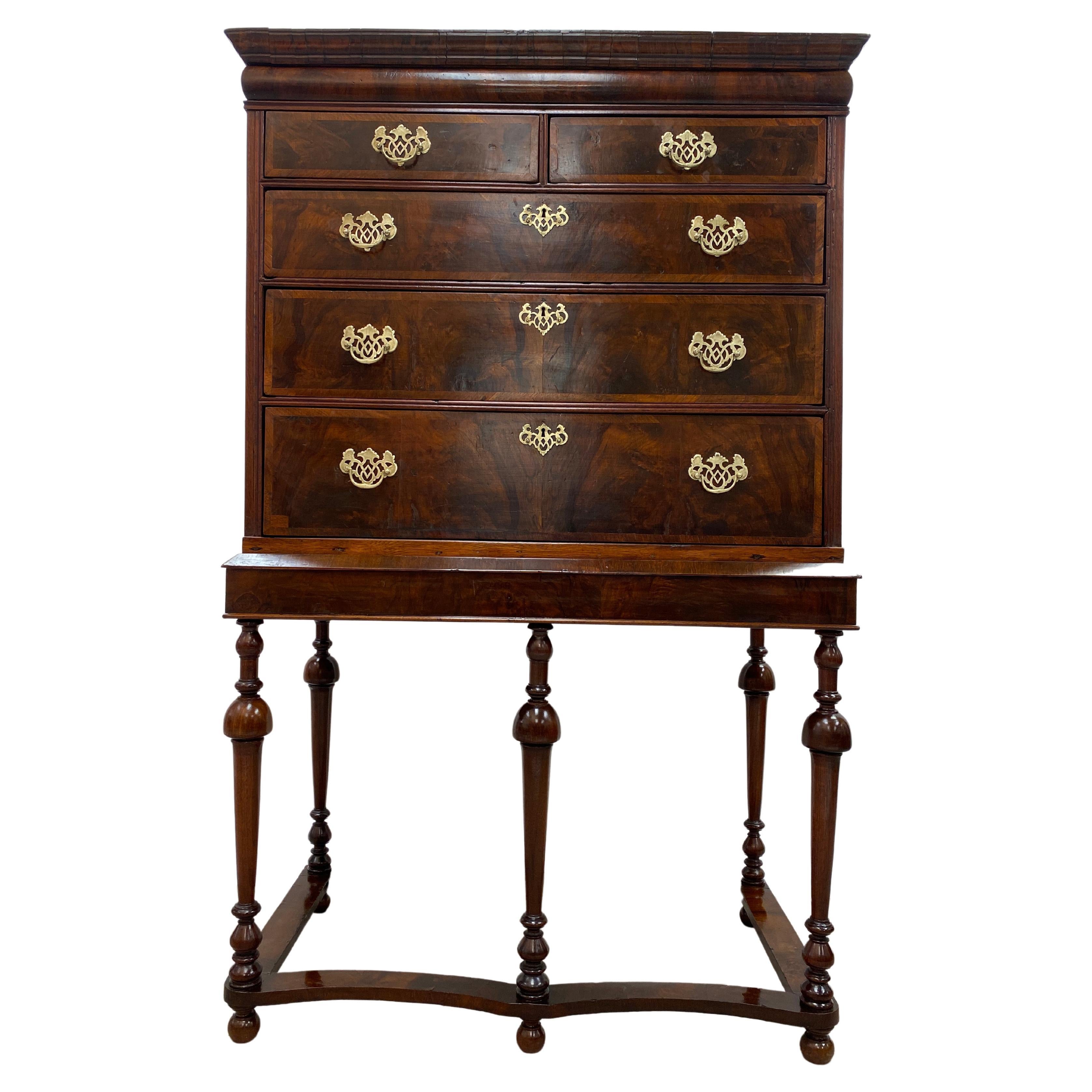 A handsome 18th century George III chest on stand containing three under two graduated drawers with brass pulls, Quartered Oak interior. Walnut and feather banding veneer work on the drawers. One single hidden top drawer. The stand is made of walnut
