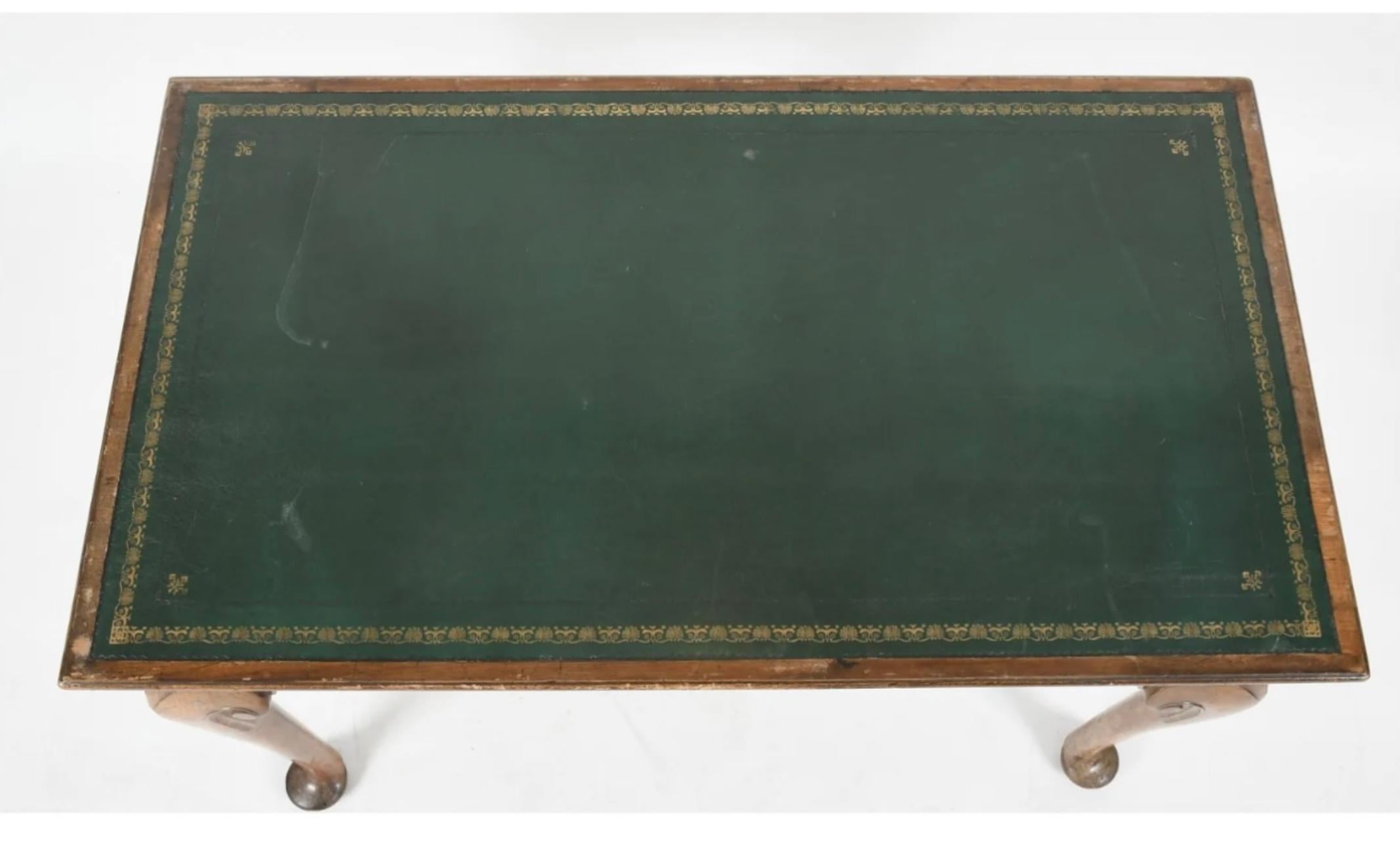 George II walnut writing table, Mid-18th Century, the molded top having a tooled green leather inset writing panel, fitted with a genuine and false frieze drawer to either side, raised on legs ending in pad feet.