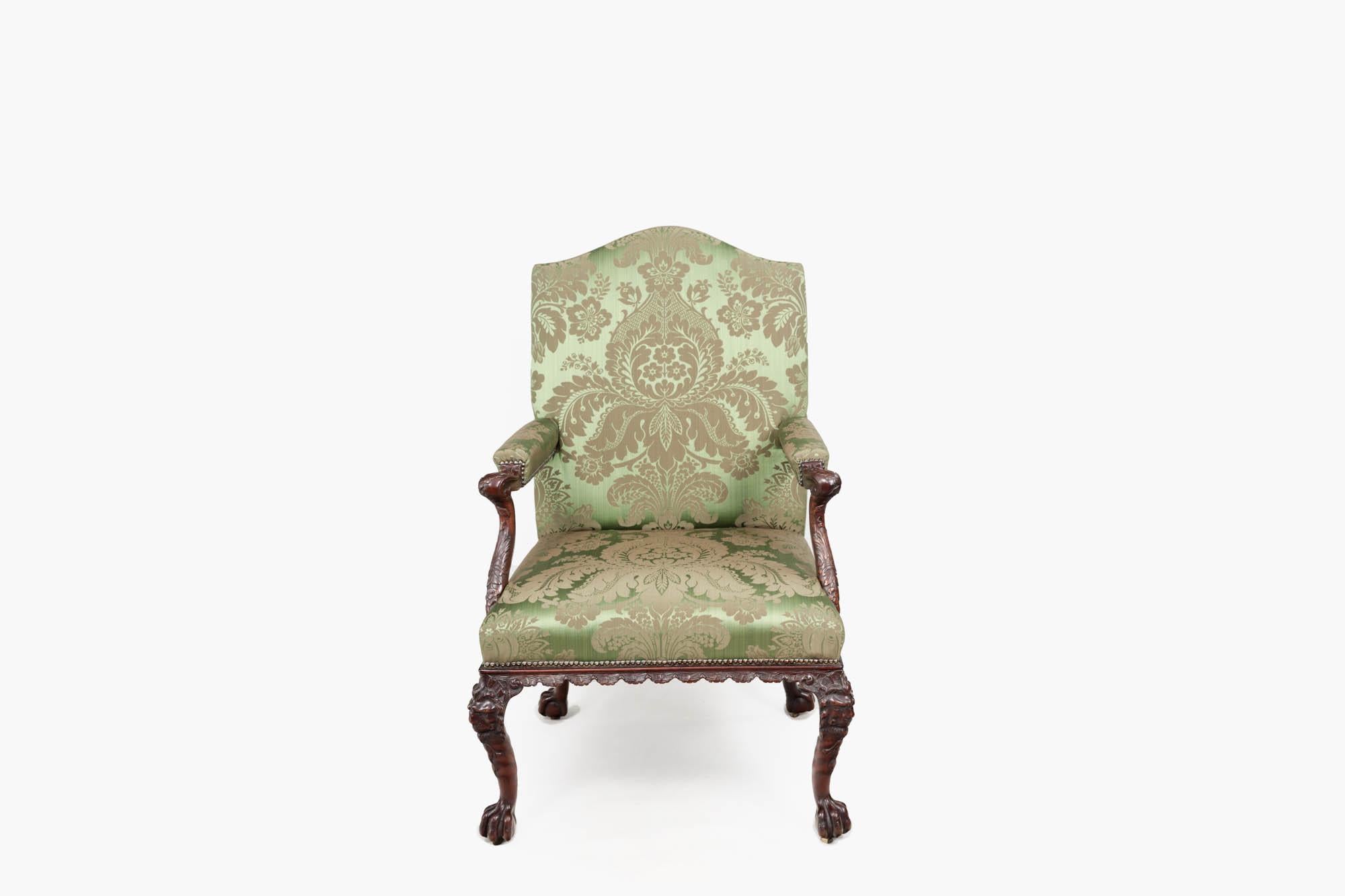 18th Century George III carved mahogany Gainsborough armchair with a gently curved upholstered back and carved, shaped arms, complete with scrolled handles and leaf-carved moldings to the supports and apron. The square seat is raised on four