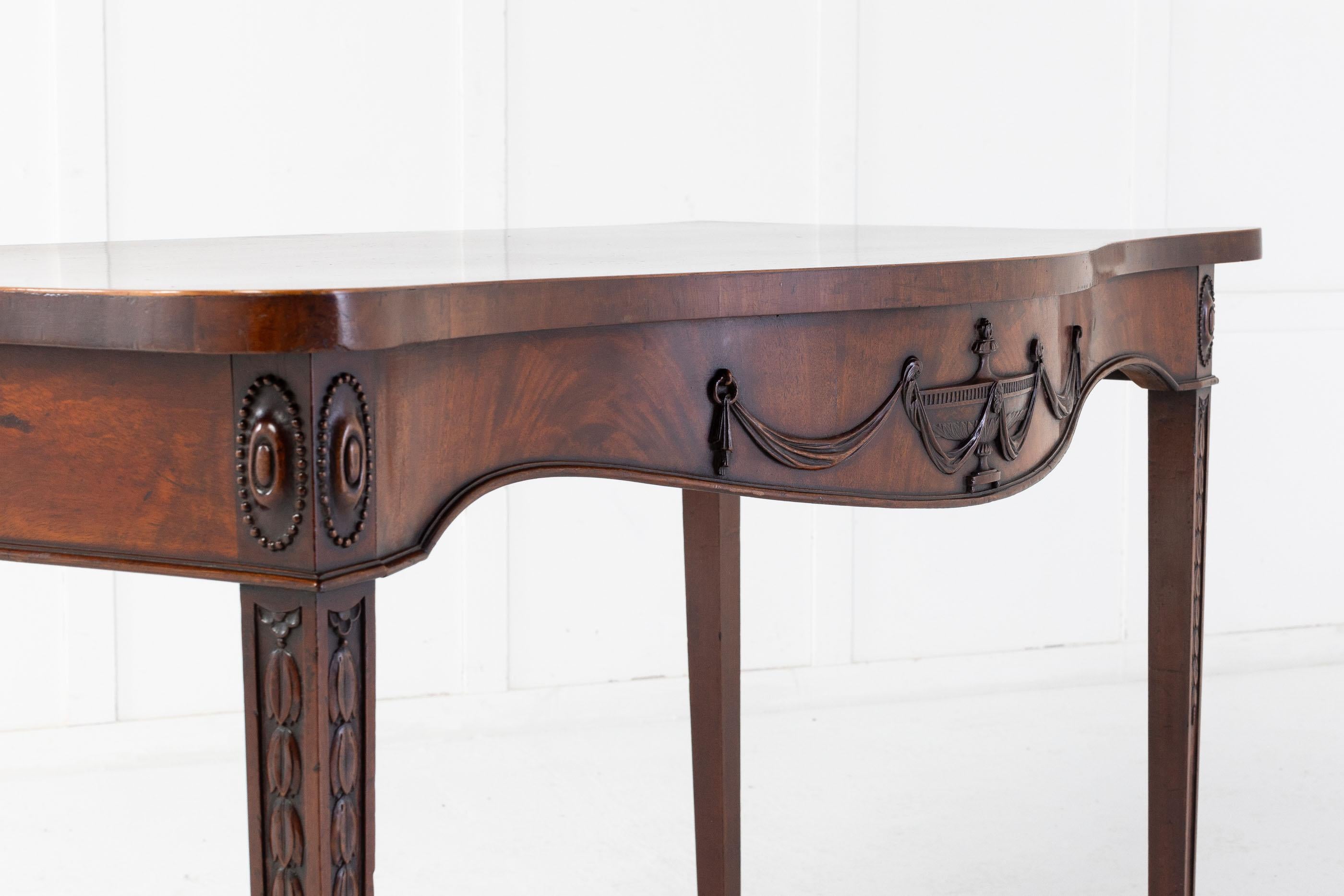 A good George III mahogany serving/side table with a serpentine front, with an 'Adam style' urn and swags carved decoration. Having square tapering legs with carved oval paterae and harebell decoration.

A nicely proportioned table.
  