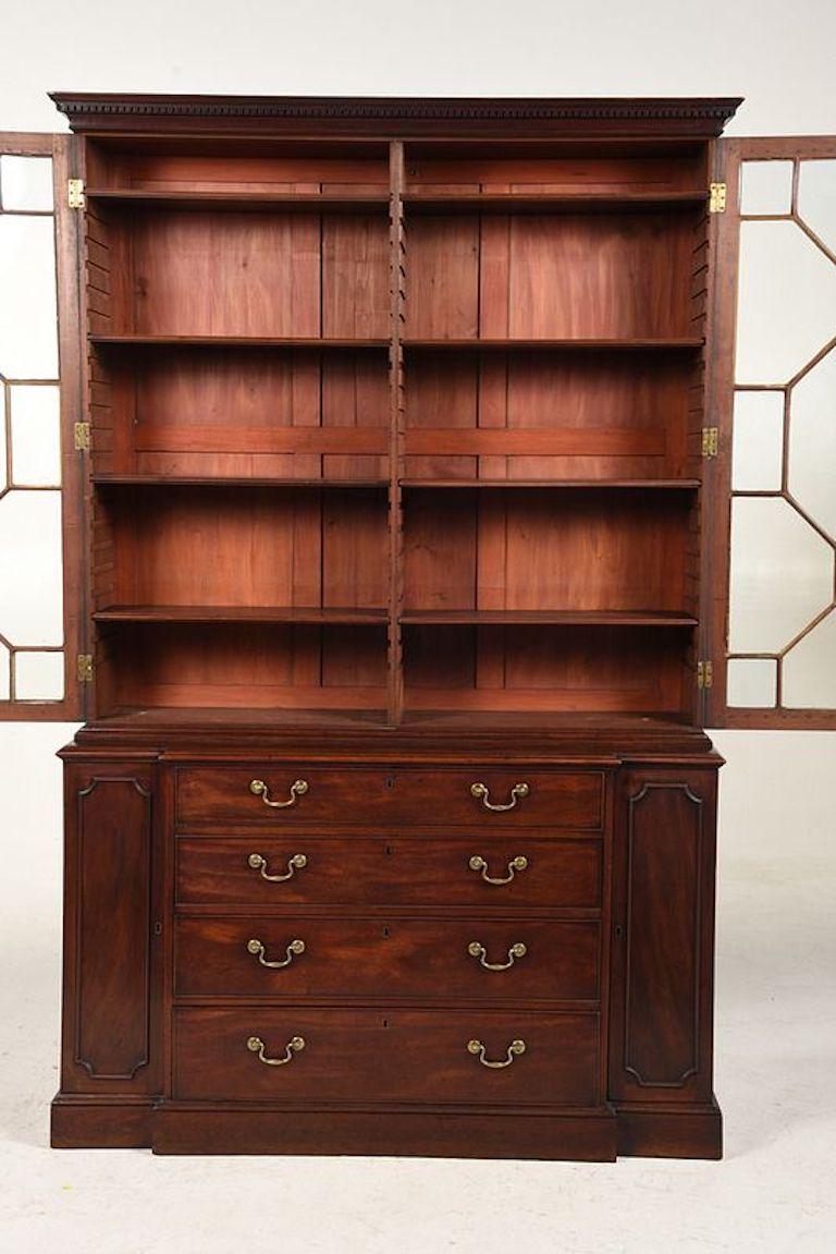 British, late 18th century, George III. Breakfront bookcase or display cabinet. Rich dark reddish brown color, with glazed upper case with shelved interior, removable cornice, interior with adjustable shelves, lower case with fitted desk drawer,