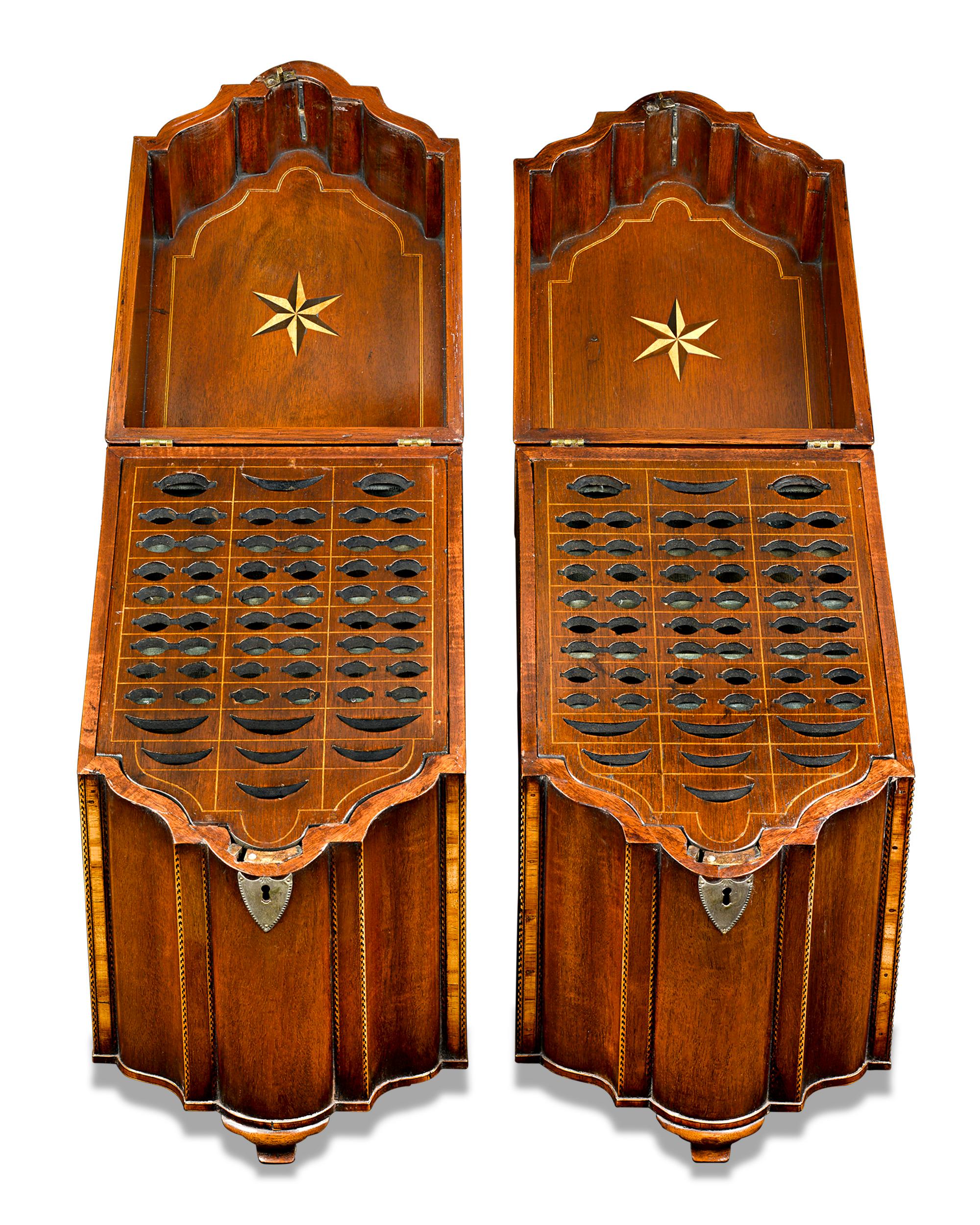 An exceedingly rare and important pair of George III-period mahogany knife boxes of exceptional quality and condition. The boxes are of serpentine form with refined crossbanded and chevron inlay work along the edges and silver mountings on the