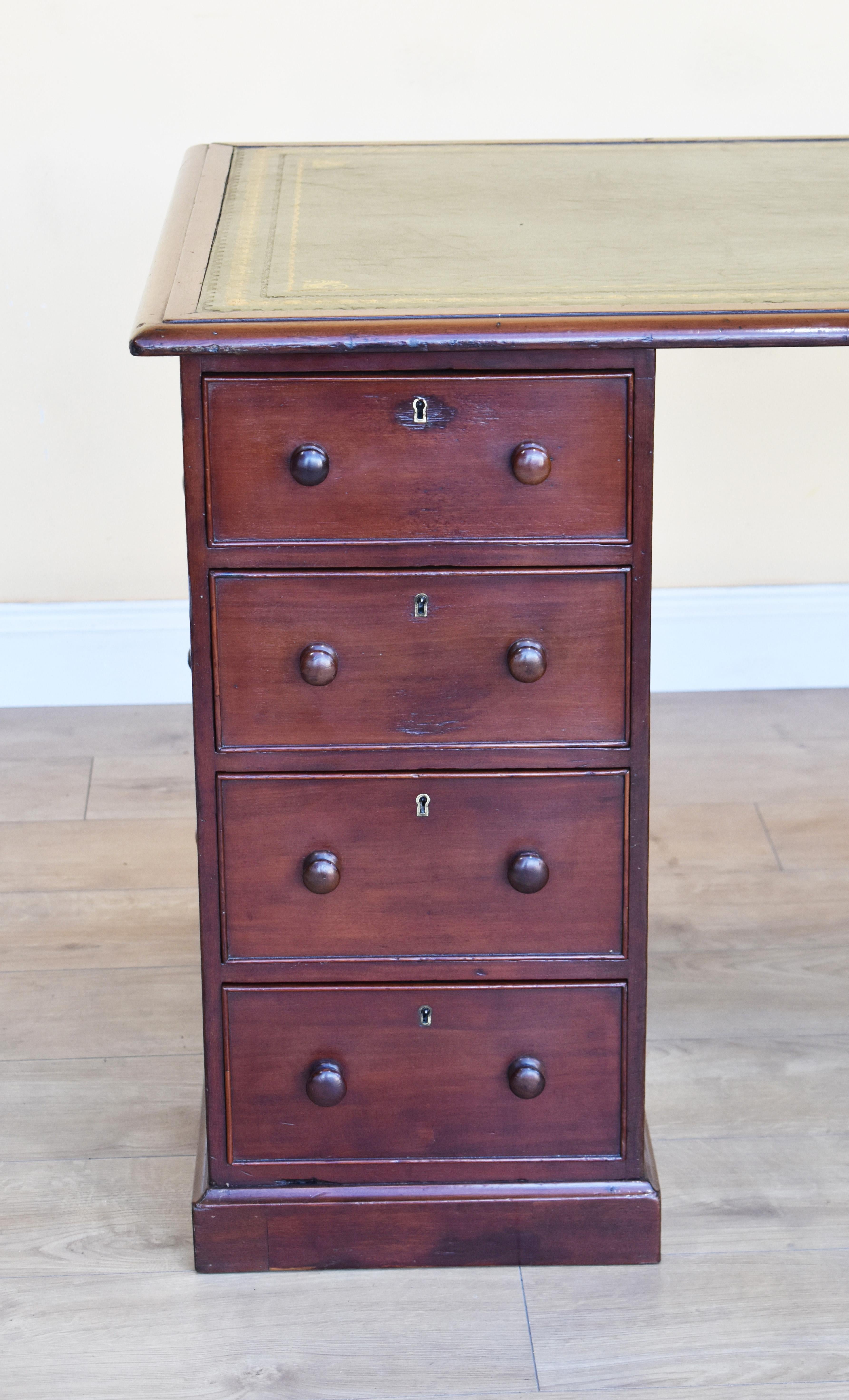 For sale is a good quality unusual George III mahogany pedestal desk. The top is inset with a green leather skiver, decorated with blind and gold tooling as well as gold corner and centre motifs. The top screws onto two pedestals, each having an