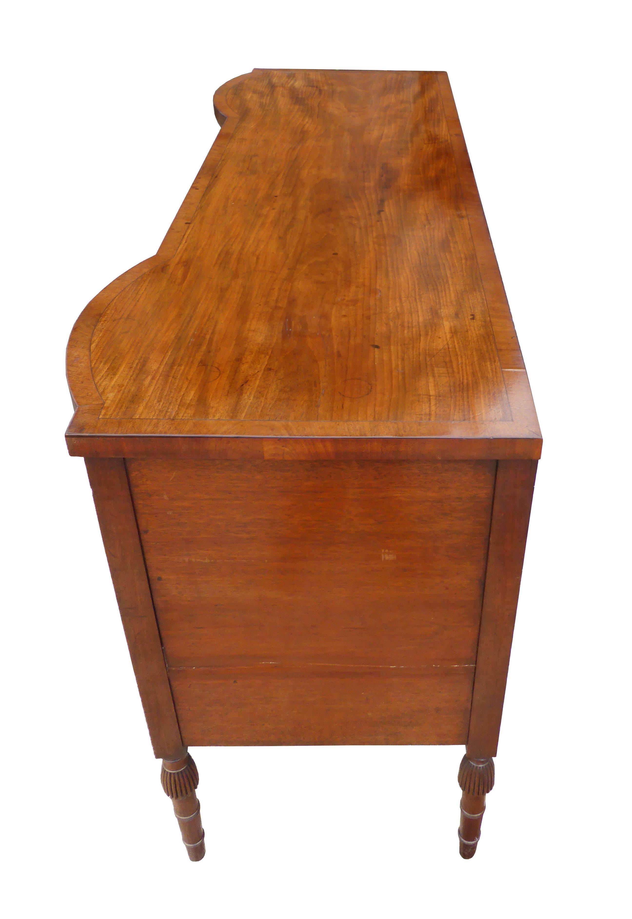 For sale is a good quality George III mahogany sideboard. The sideboard has three drawers across the top, each with ring handles. These are above to bowed cupboards, one opening to reveal a fitted interior for bottles etc. In the centre is a small