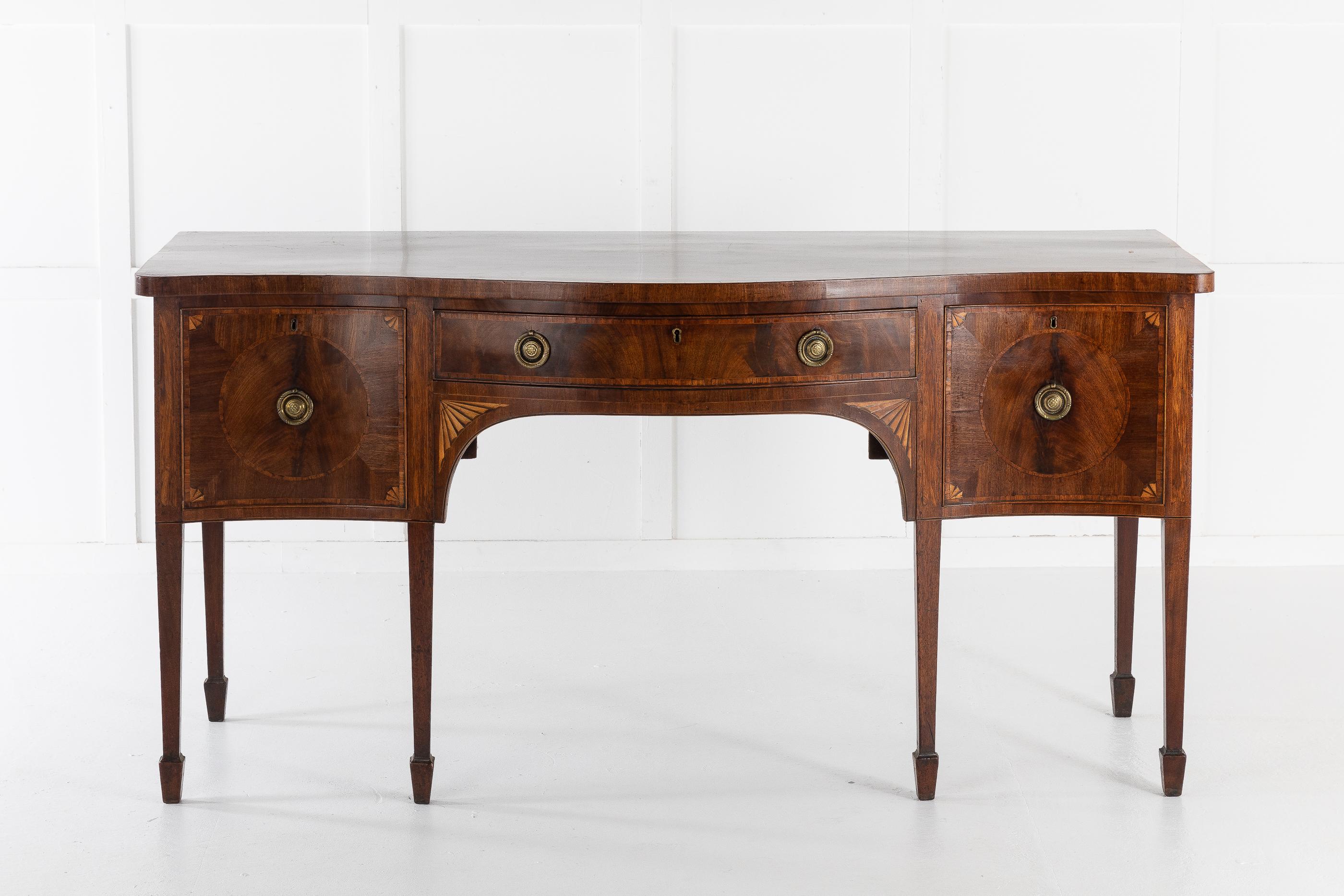 18th century George III mahogany inlaid and cross banded, serpentine front sideboard, on square tapering legs and spade feet. Good original condition and color. Wonderful piece of mahogany veneer used for the top.