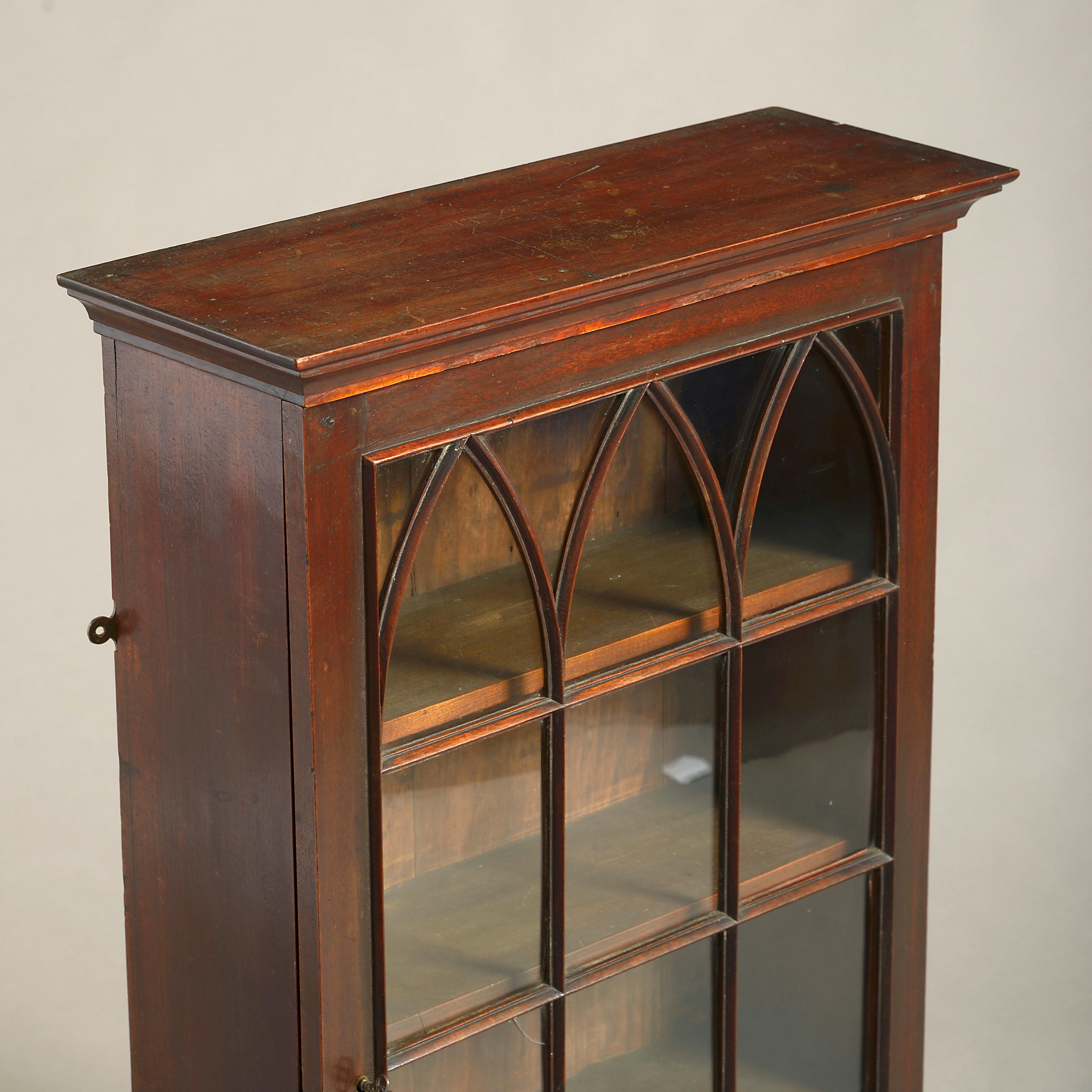 A mid-18th century George III Period mahogany hanging cabinet of small scale, having a cornice above a glazed door with gothic astragals, the interior fitted with shelves.