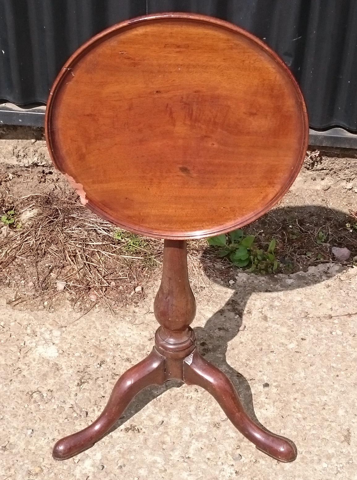 George III period mahogany antique wine table with raised turned edge standing on especially elegant baluster turned column support and tripod base with shapely knee and slender ankles. This table is unusually low for the period so it might be just