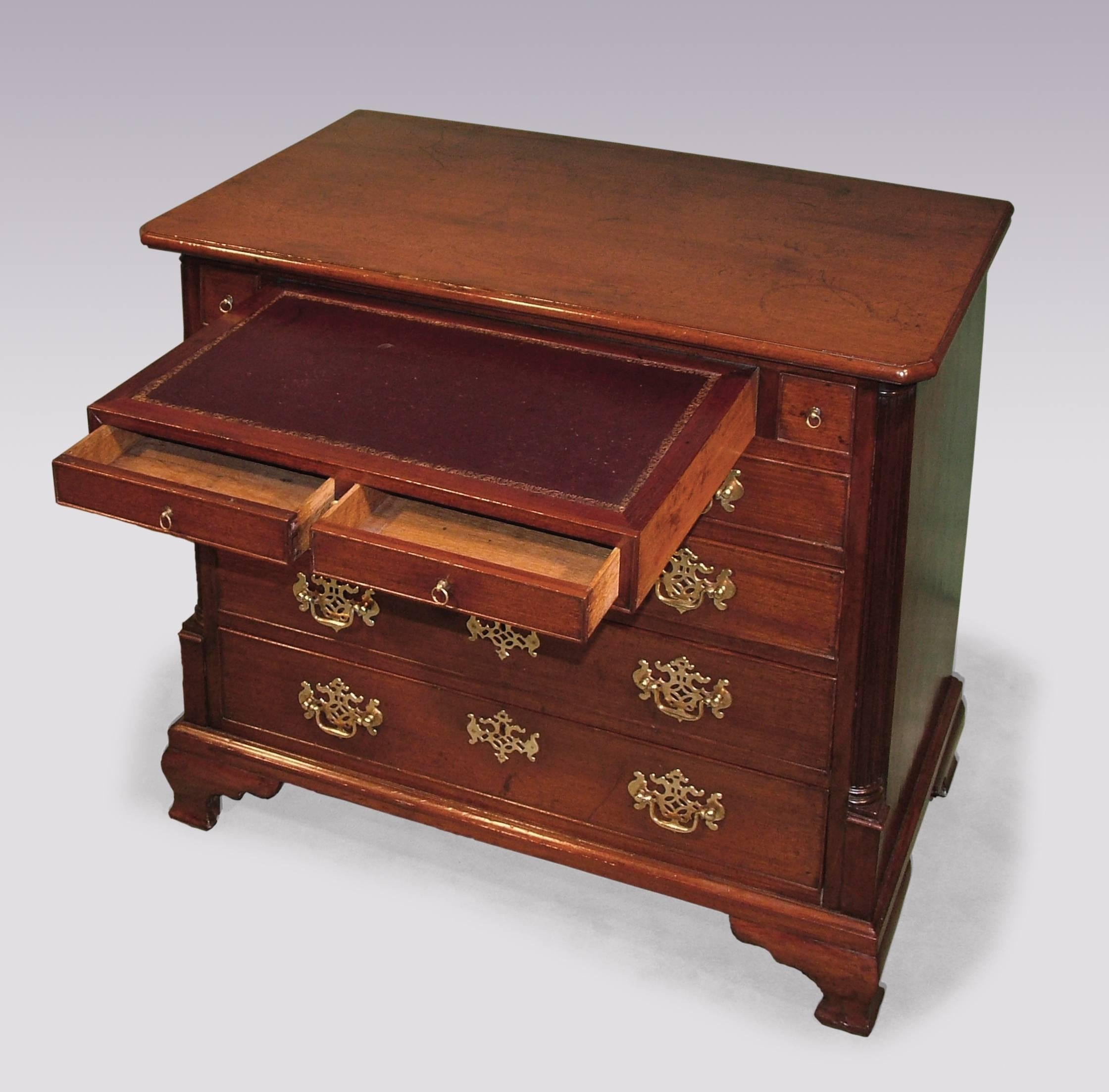 A mid-18th century George III period mahogany chest, having moulded edged, canted cornered top above graduated drawers and unusual double leather top writing drawer, flanked by fluted quadrant corners, supported on ogee bracket feet.