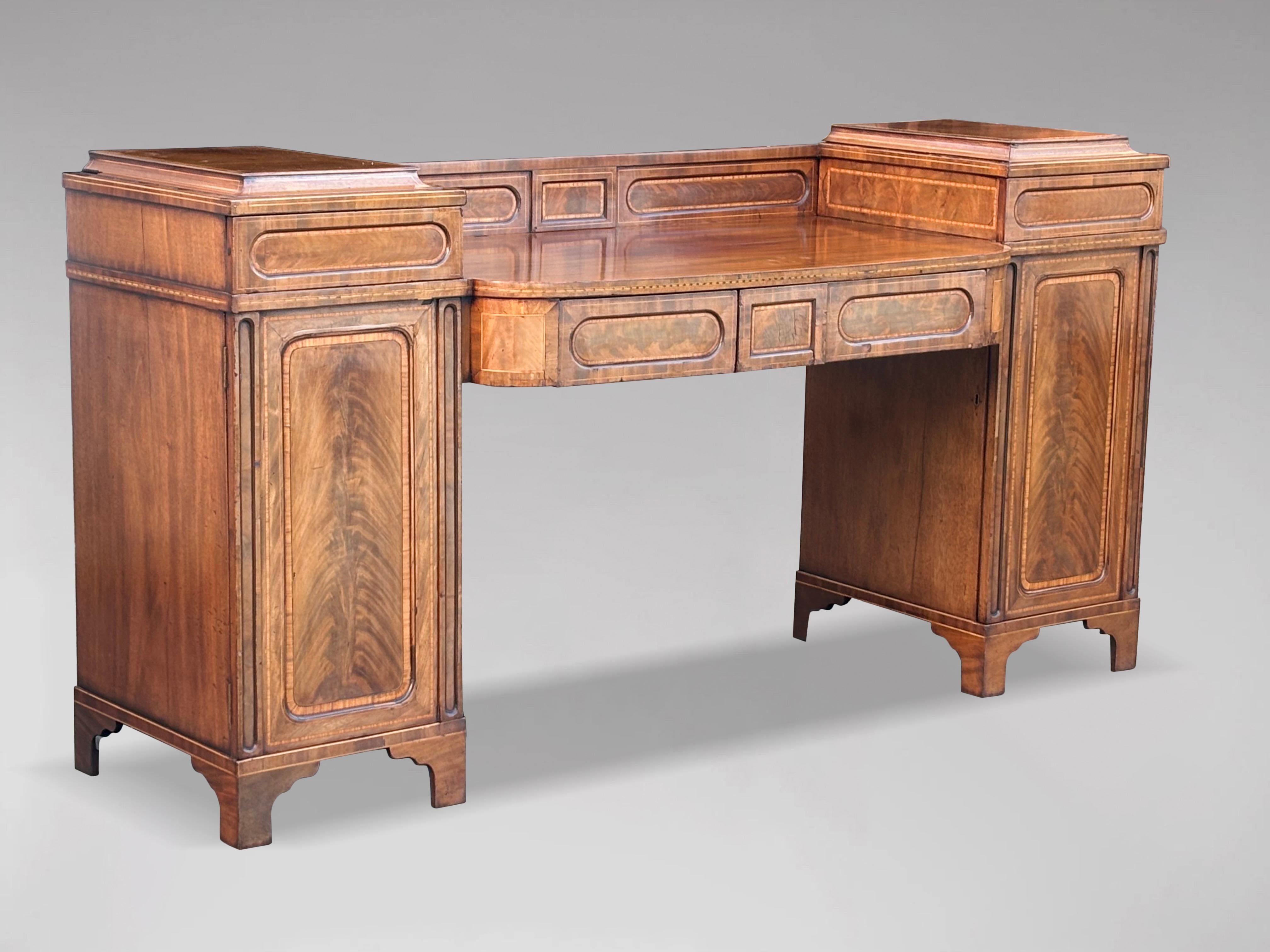 A late 18th century very fine and untouched George III period well figured mahogany pedestal sideboard. The bow fronted central section with satinwood and rosewood inlay and shaped with a straight inlaid back, above two long frieze drawers with