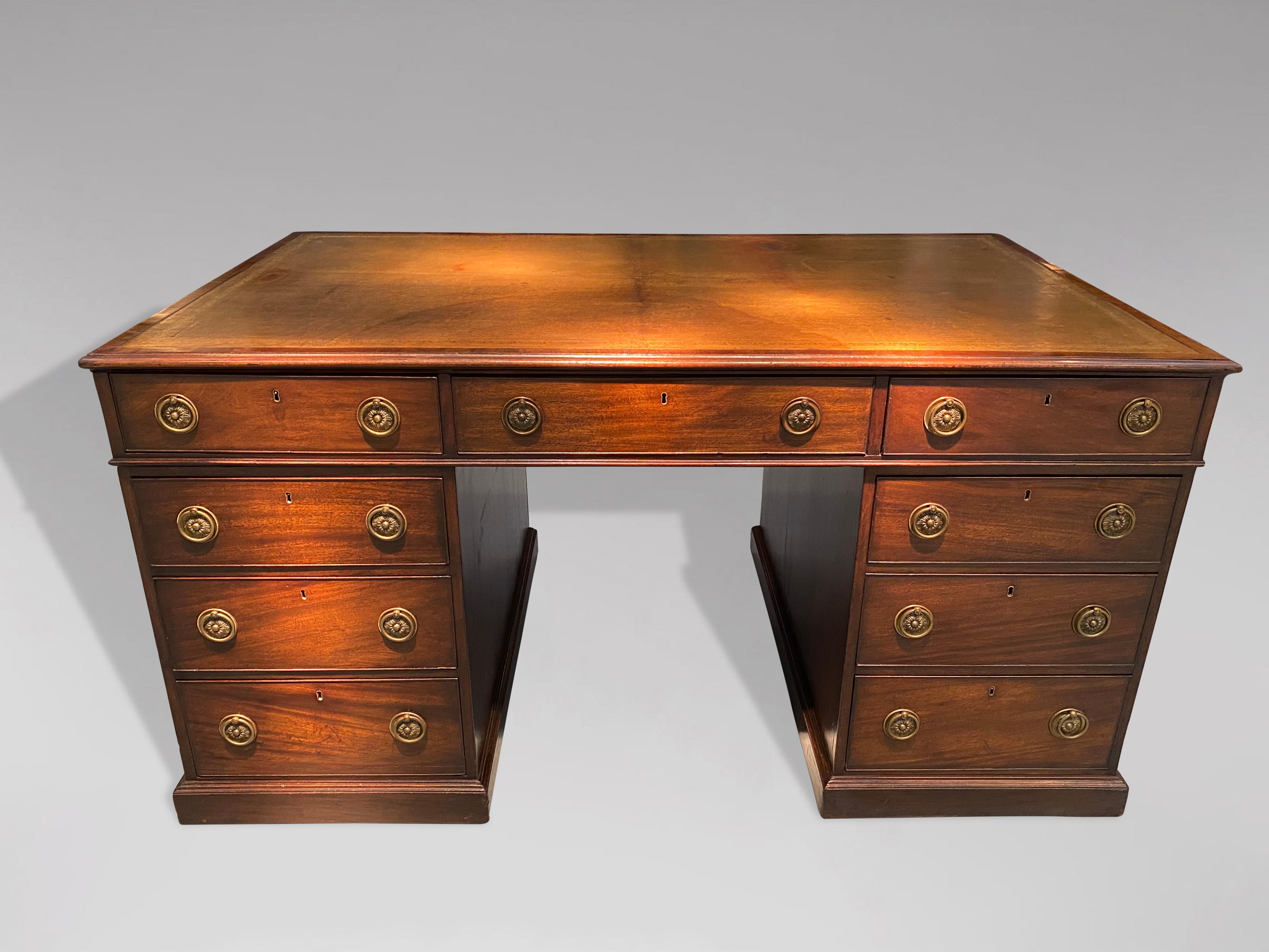 A stunning late 18th century George III period mahogany partners desk. Nine oak lined drawers to one side and three oak lined drawers and two cupboards to the other side. A golden green colour tooled leather inset to top with thumb moulded edge over