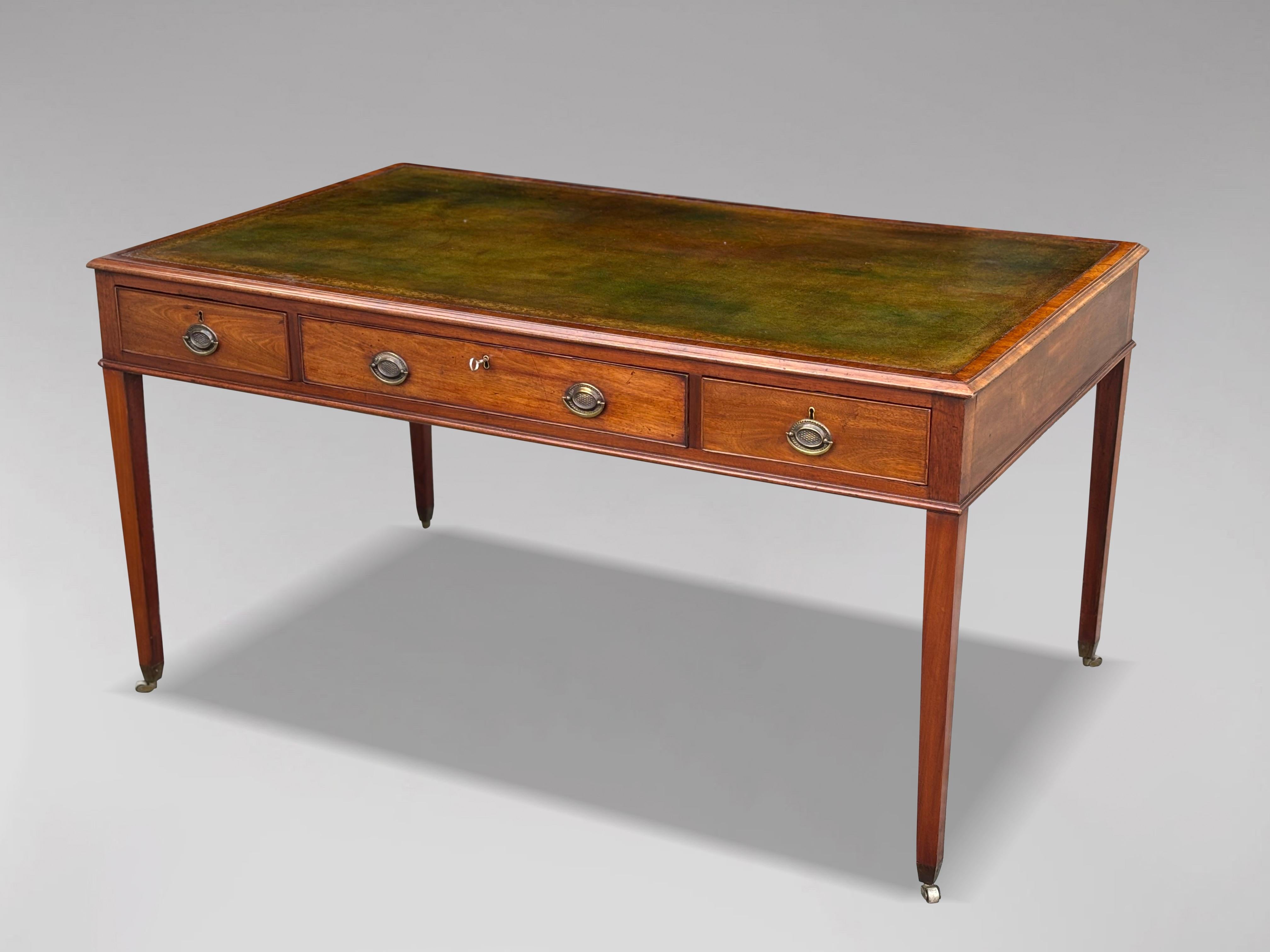 Esta excelente mesa de escritorio de caoba de finales del siglo XVIII es una pieza extraordinaria. Fabricada en caoba maciza, tiene el borde moldeado y la parte superior rectangular con esquinas cuadradas moldeadas, y luce una hermosa inserción de