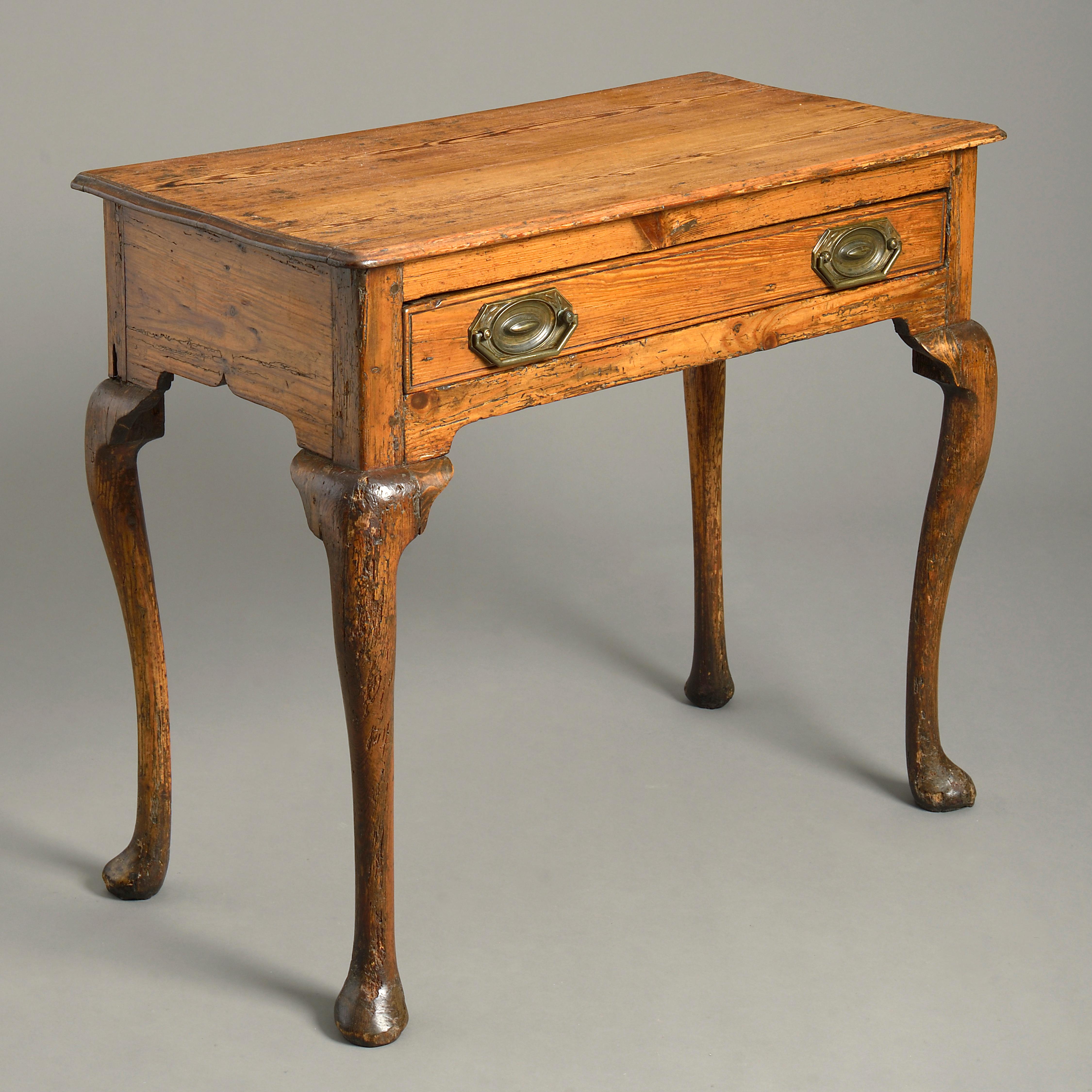 A charming mid-18th century pine side table, the overhanging top above a single drawer with Regency Period handles, all raised upon generously carved cabriole legs with pad feet.