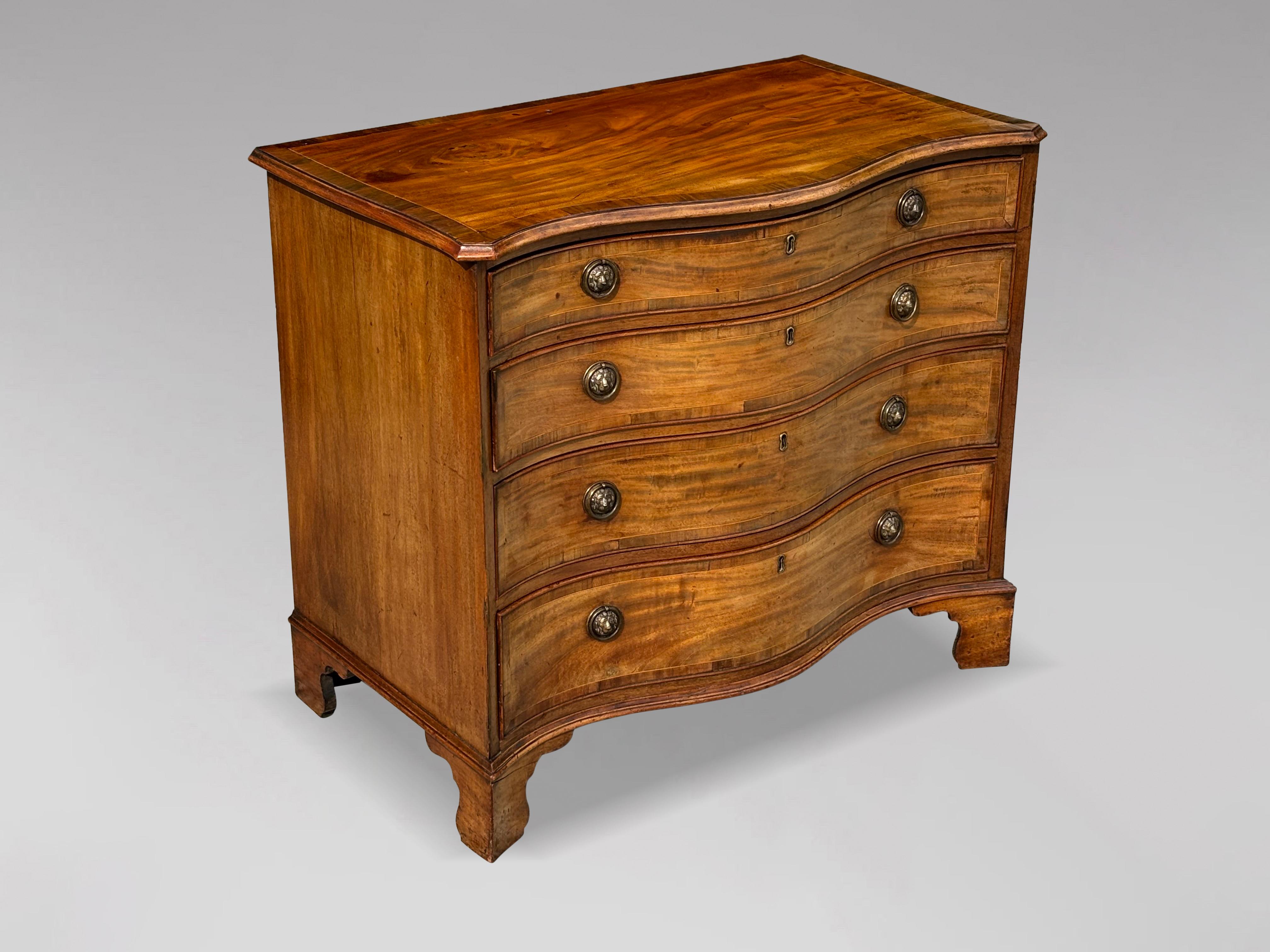 Raffinata cassettiera in mogano della fine del XVIII secolo, di epoca Giorgio III. Presenta un piano a fascia incrociata modellato a serpentina che sovrasta quattro lunghi cassetti graduati rivestiti in rovere, ognuno dei quali è ornato da maniglie