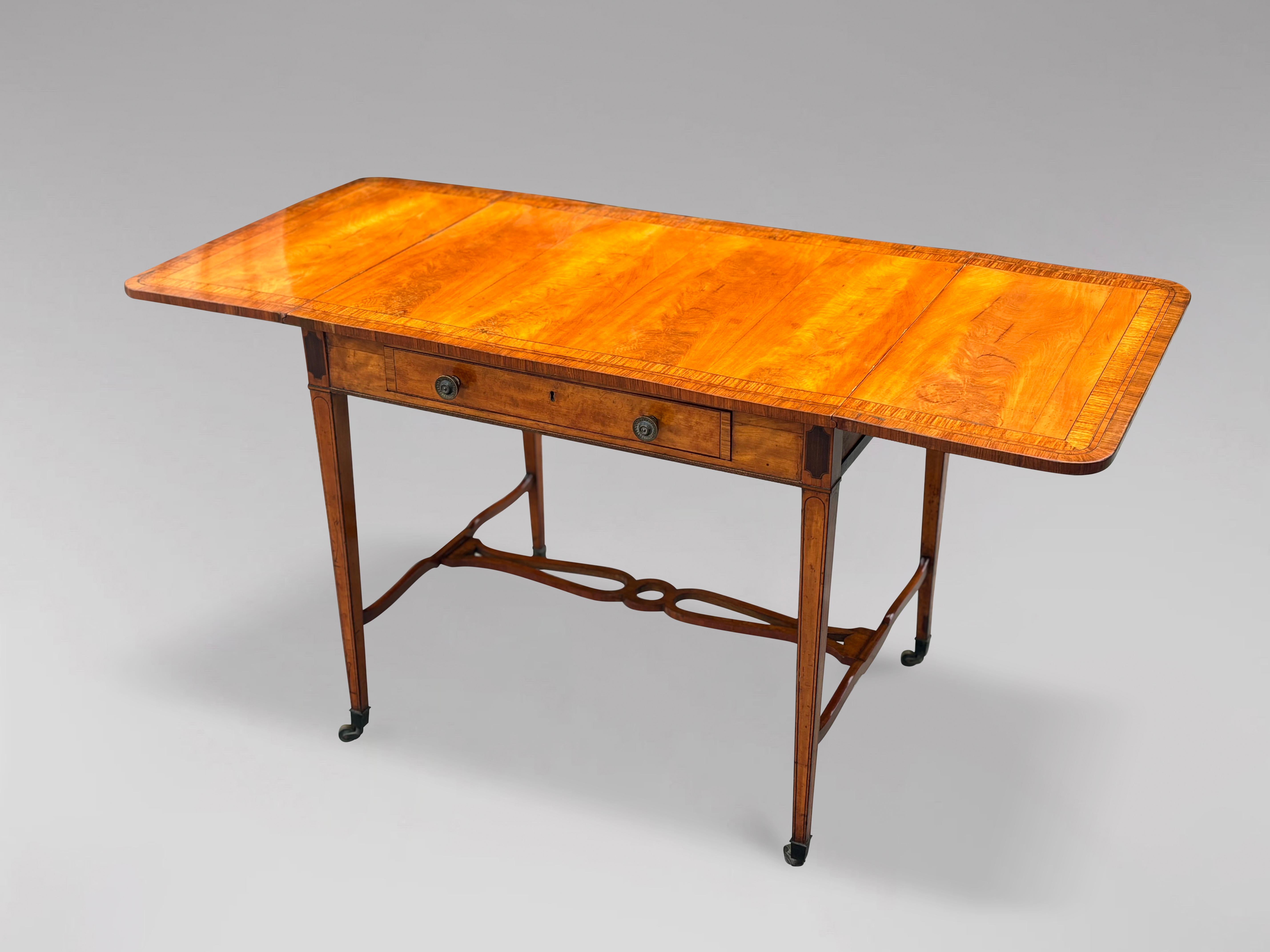 Fina mesa de sofá o pembroke de madera satinada de finales del siglo XVIII, época de Jorge III Sheraton. La encimera rectangular de madera de satén bien labrada con listones de palisandro, boj y ébano, sobre un cajón largo forrado de roble con