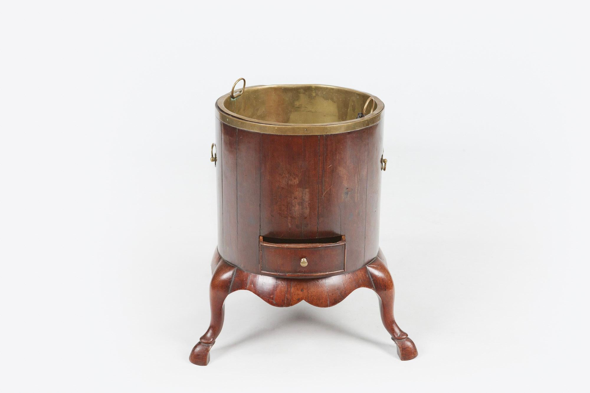 18th century George III mahogany brass bound wine cooler or planter of circular form with decorative brass carrying handles and brass insert with single cockbeaded drawer raised over shaped apron supported on three cabriole legs terminating on Manx