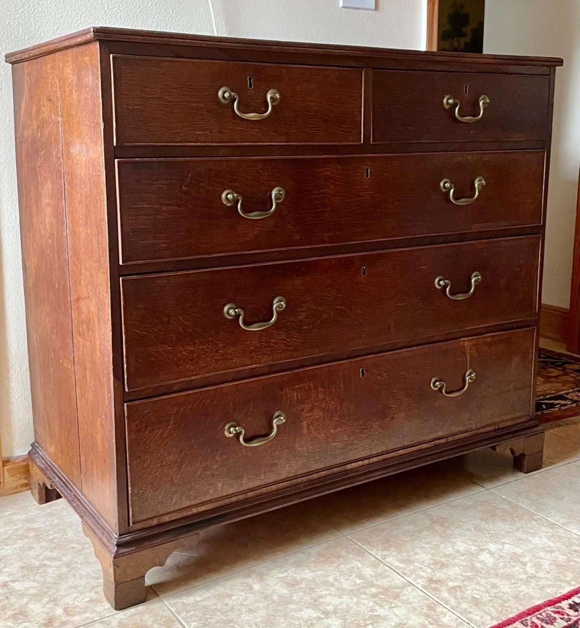 18th Century George lll oak chest of drawers with original hardware.

Original and period 18th century oak chest of drawers. This English chest retains the original brass swan neck handles and original locks. (Key absent) The antique chest is