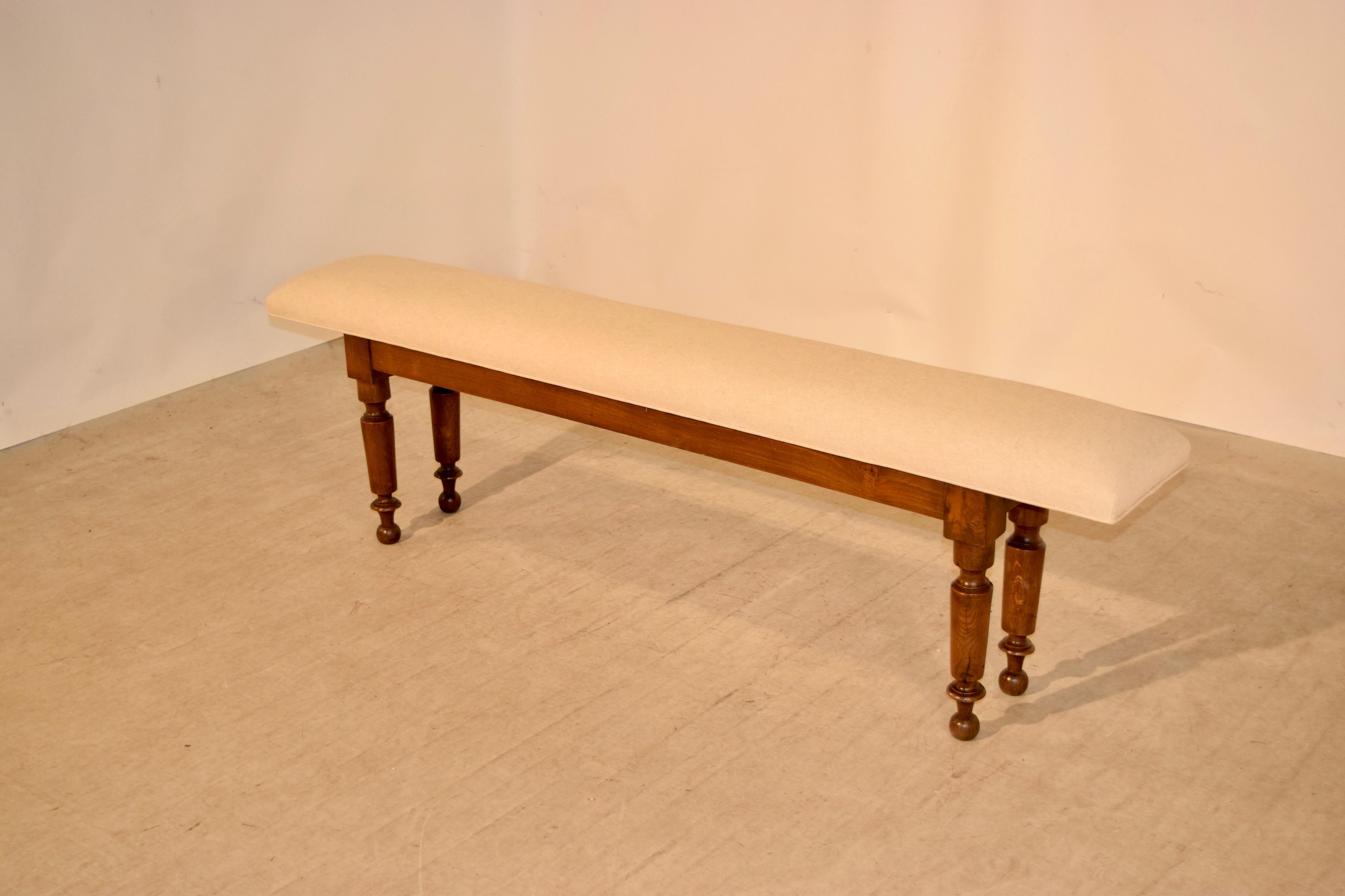 18th century Georgian bench made from oak with a newly upholstered seat in linen. The legs are nicely turned and have signs of old shrinkage. Great length.