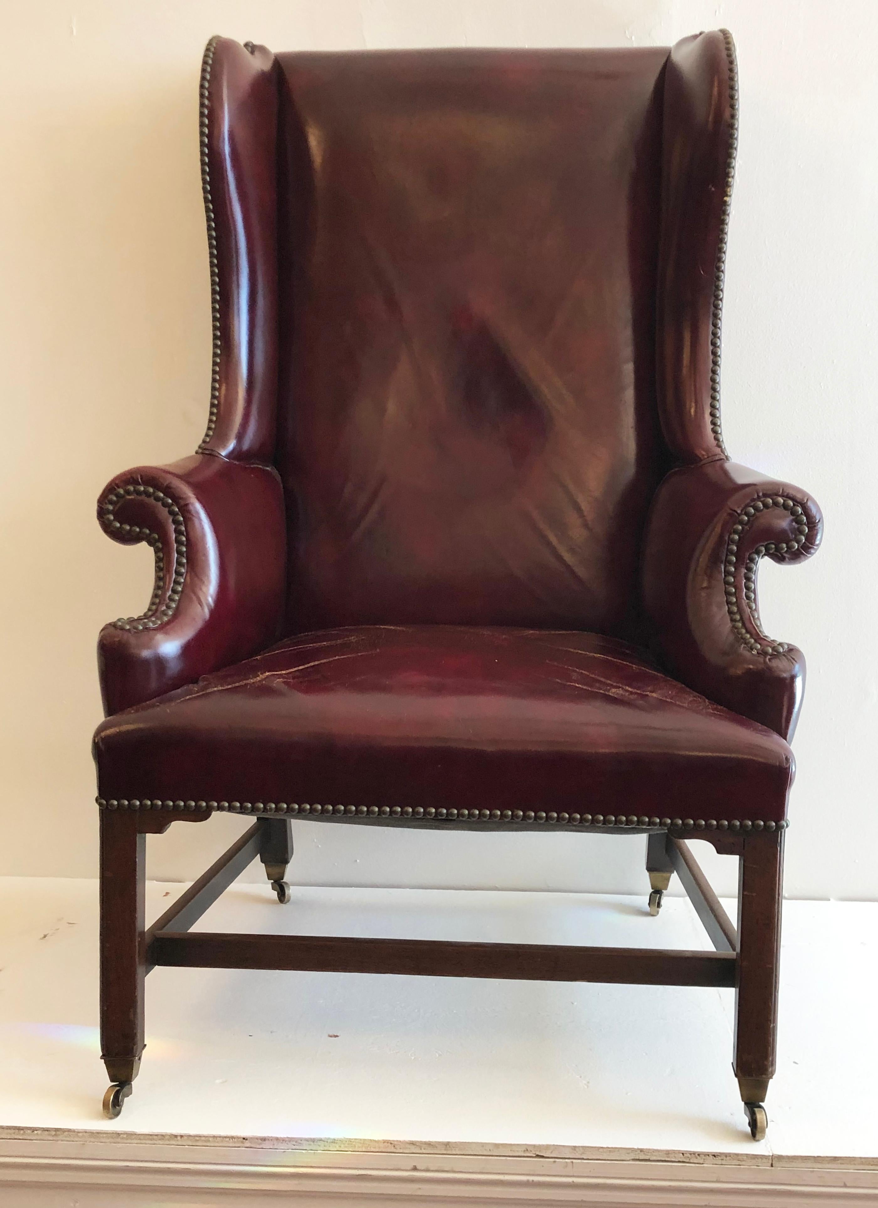 Classic 18th century Georgian Chippendale wing chair, made of mahogany and upholstered in leather. Raised on moulded mahogany marlborough shaped legs with brass casters. Wonderful chinoiserie design often found in the 18th century Chippendale period.
